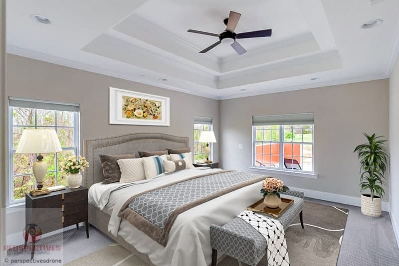 A bedroom with a ceiling fan and a bed.