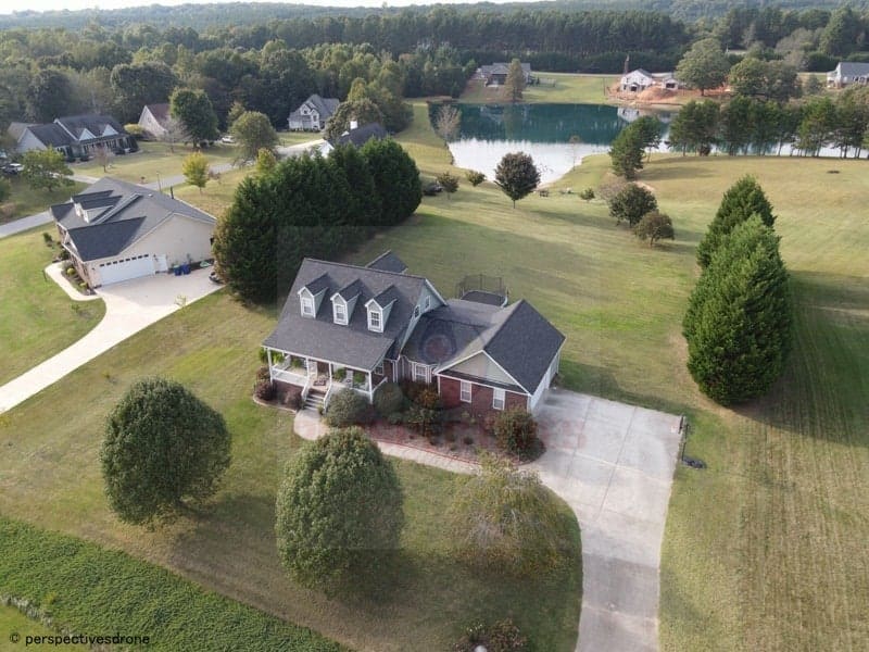 An aerial view of a home and a lake.