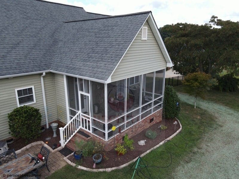 An aerial view of a home with a screened porch.