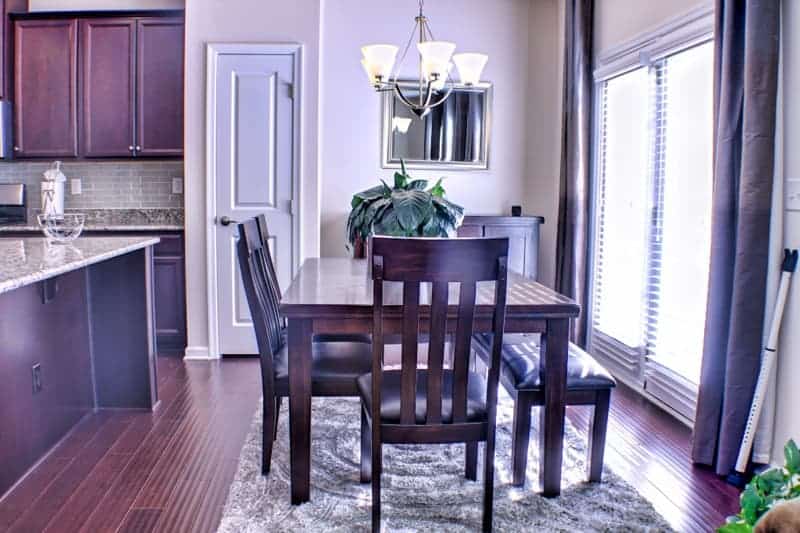 A kitchen with a dining table and chairs.