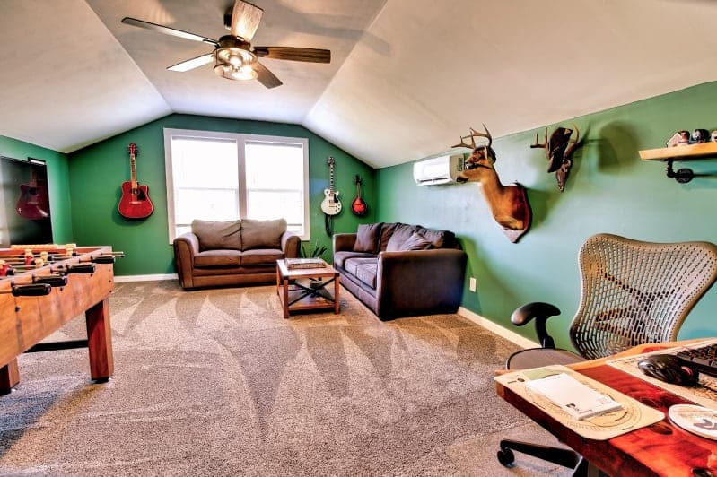 A green living room with a foosball table and guitars.