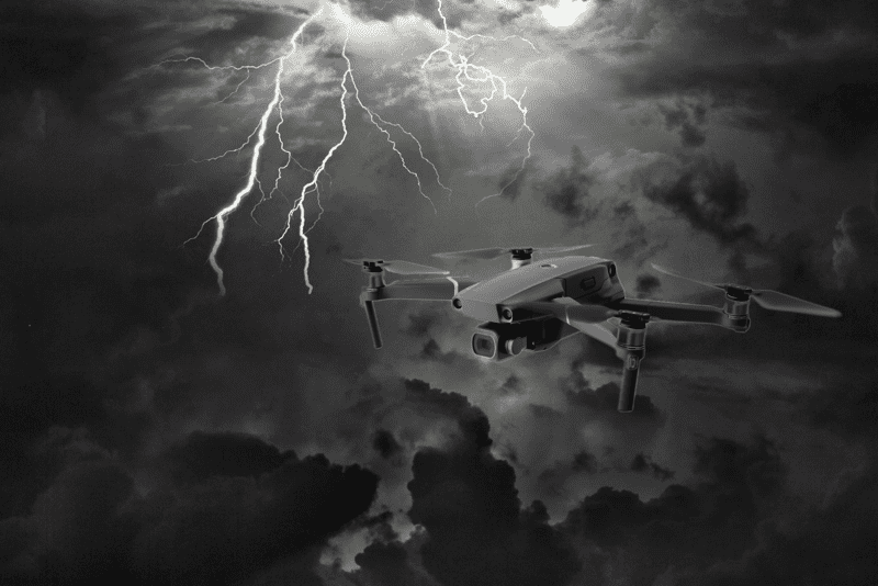 A black and white photo of a drone flying in the sky.