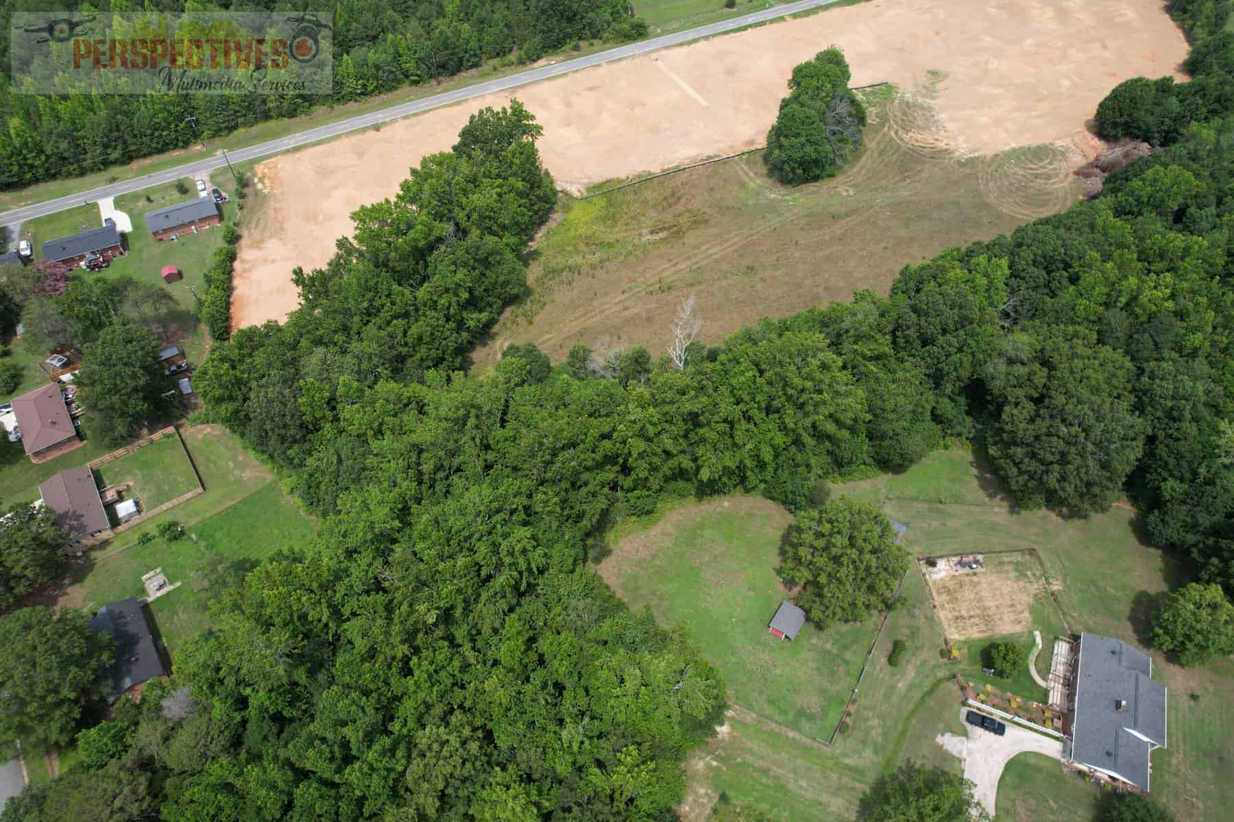 An aerial view of a field and trees.