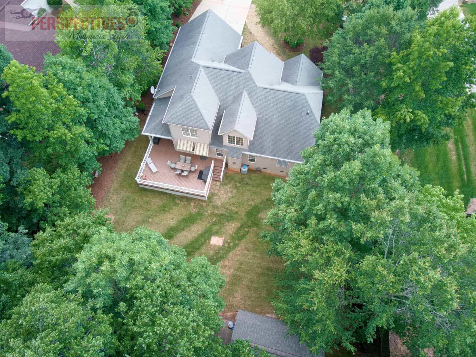 A house with a deck and trees.