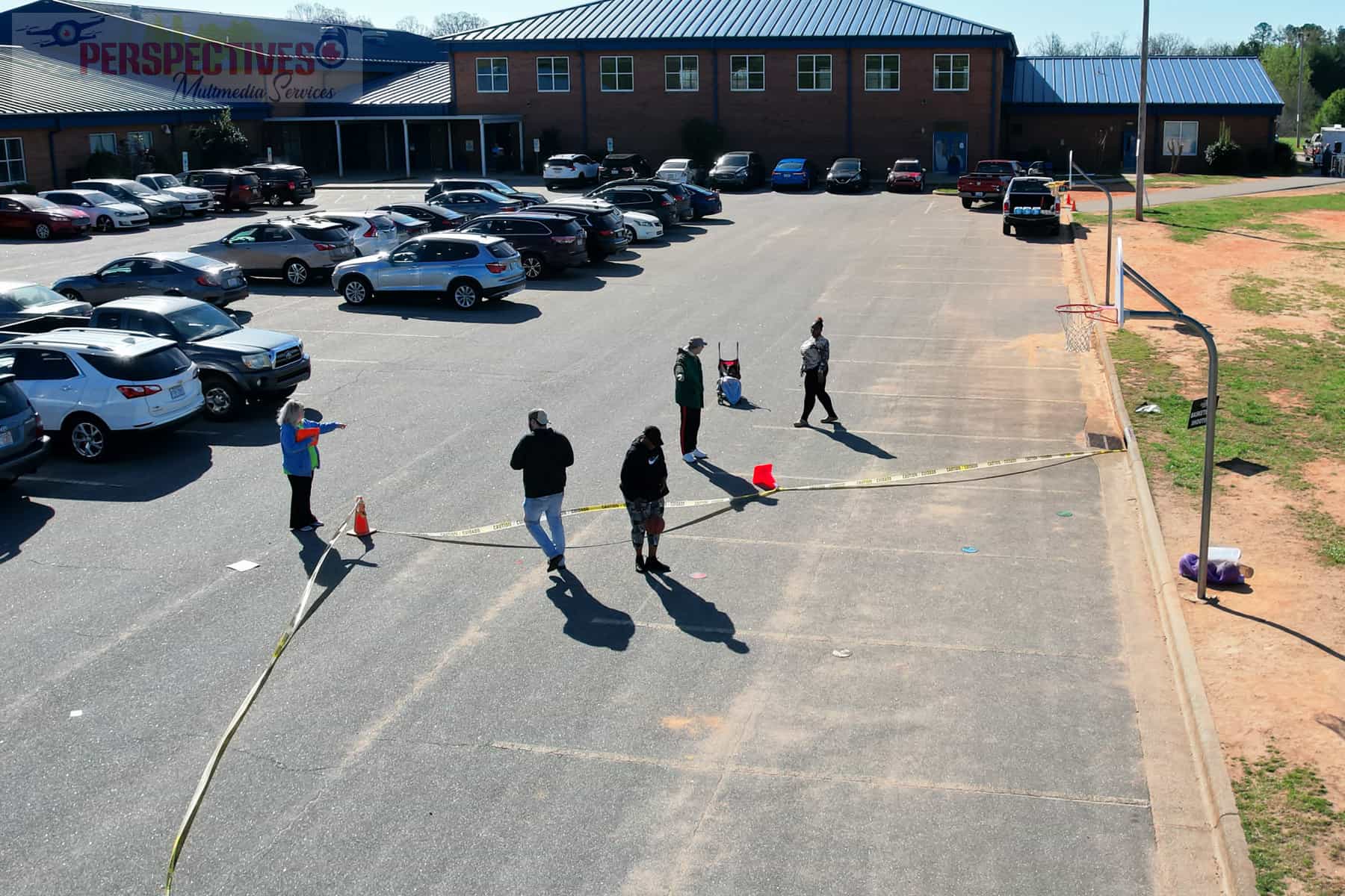 A group of people standing in a parking lot.