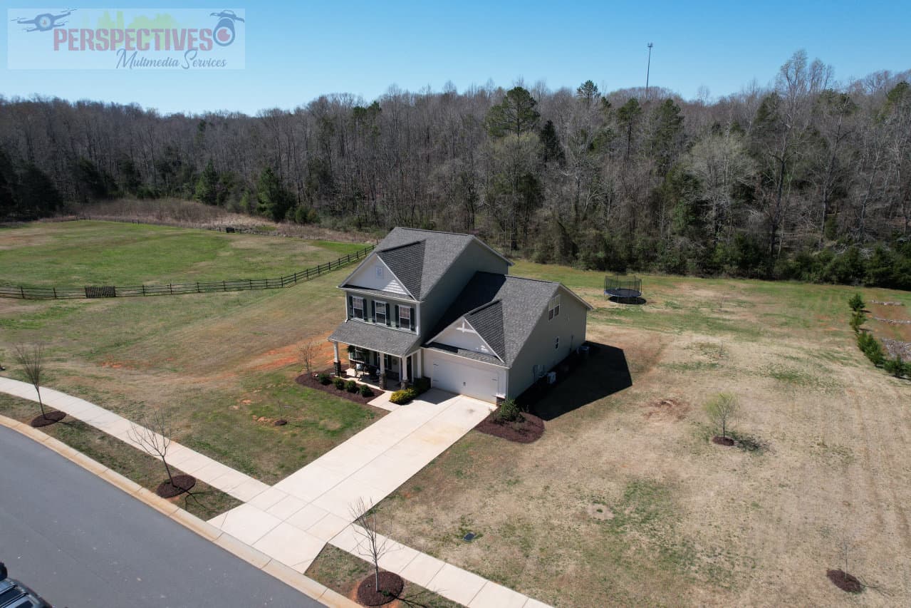 A house with a driveway and grass and trees.