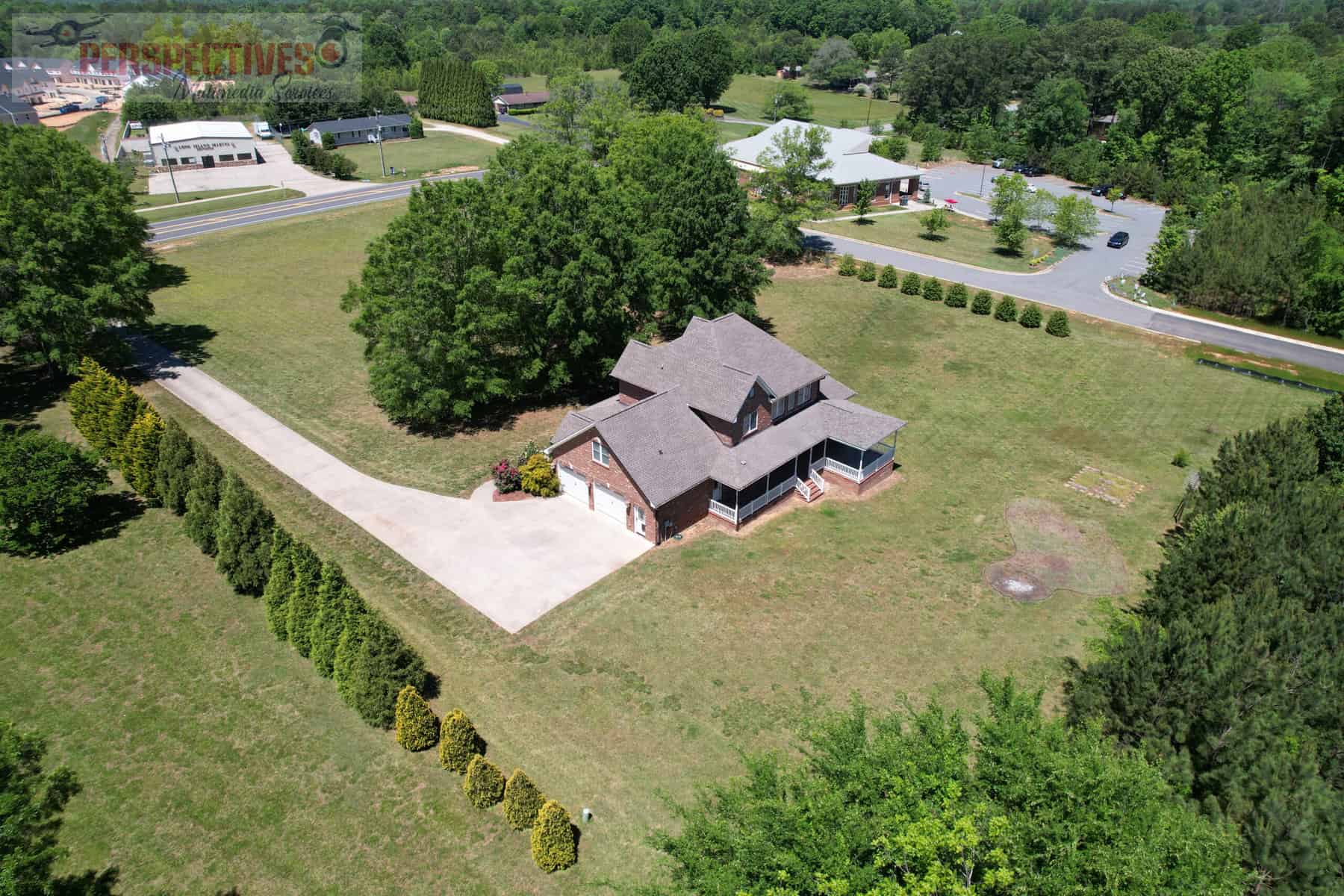 An aerial view of a house in the middle of a wooded area.