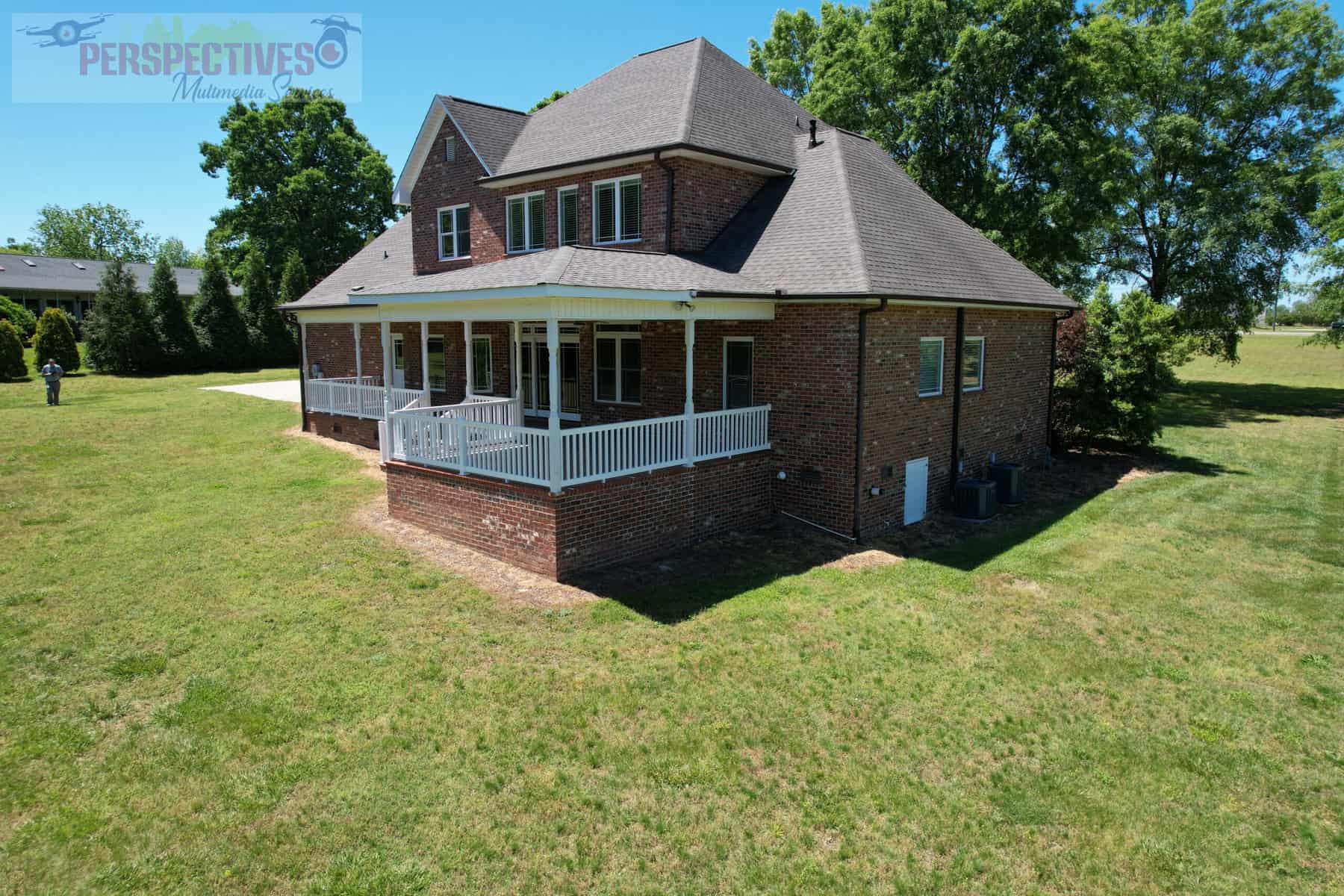 A house with a porch and a lawn.