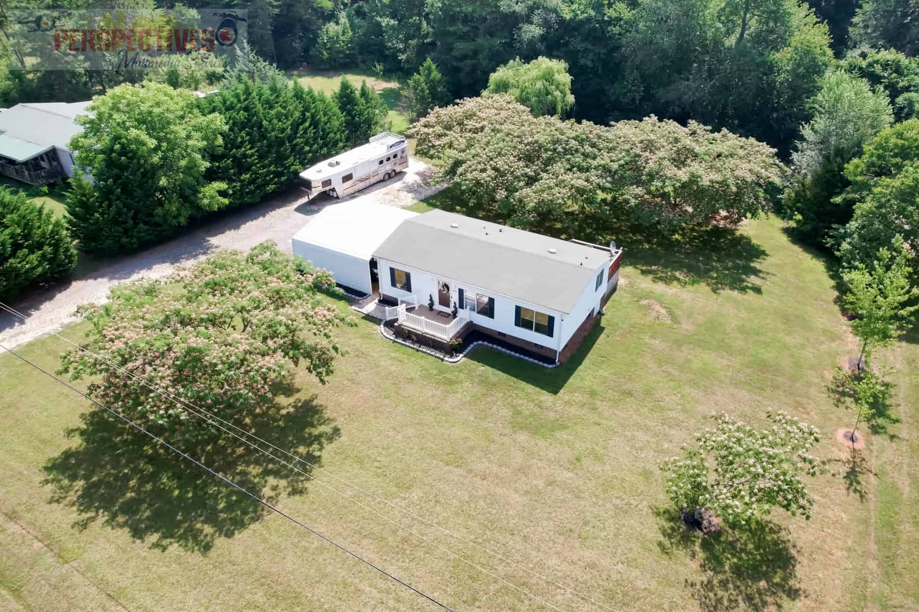 A house with a large lawn and trees.