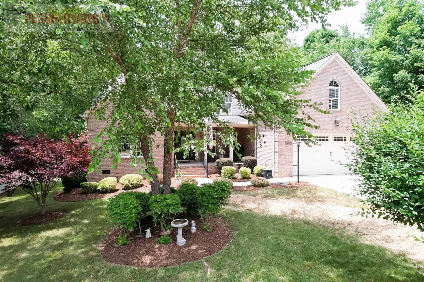 A house with a tree and yard.