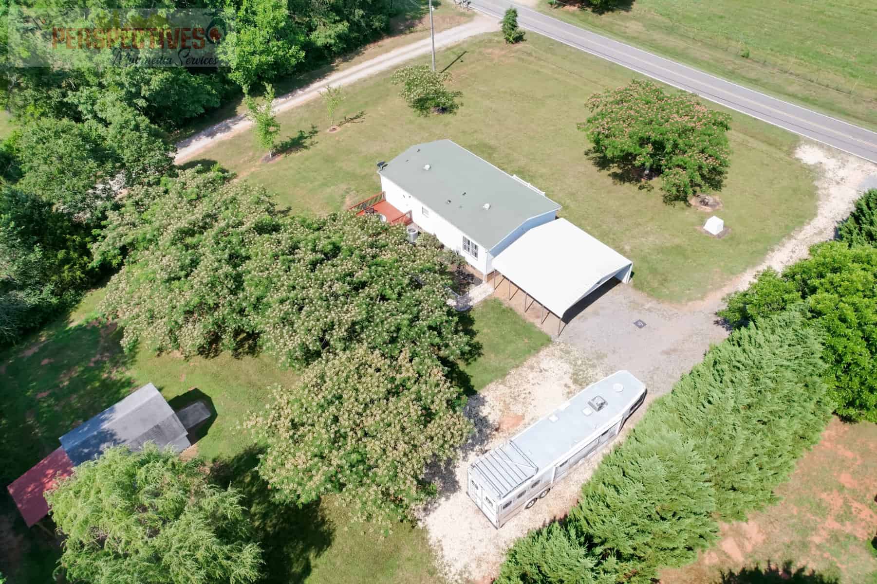 A house with a trailer in the middle of a yard.