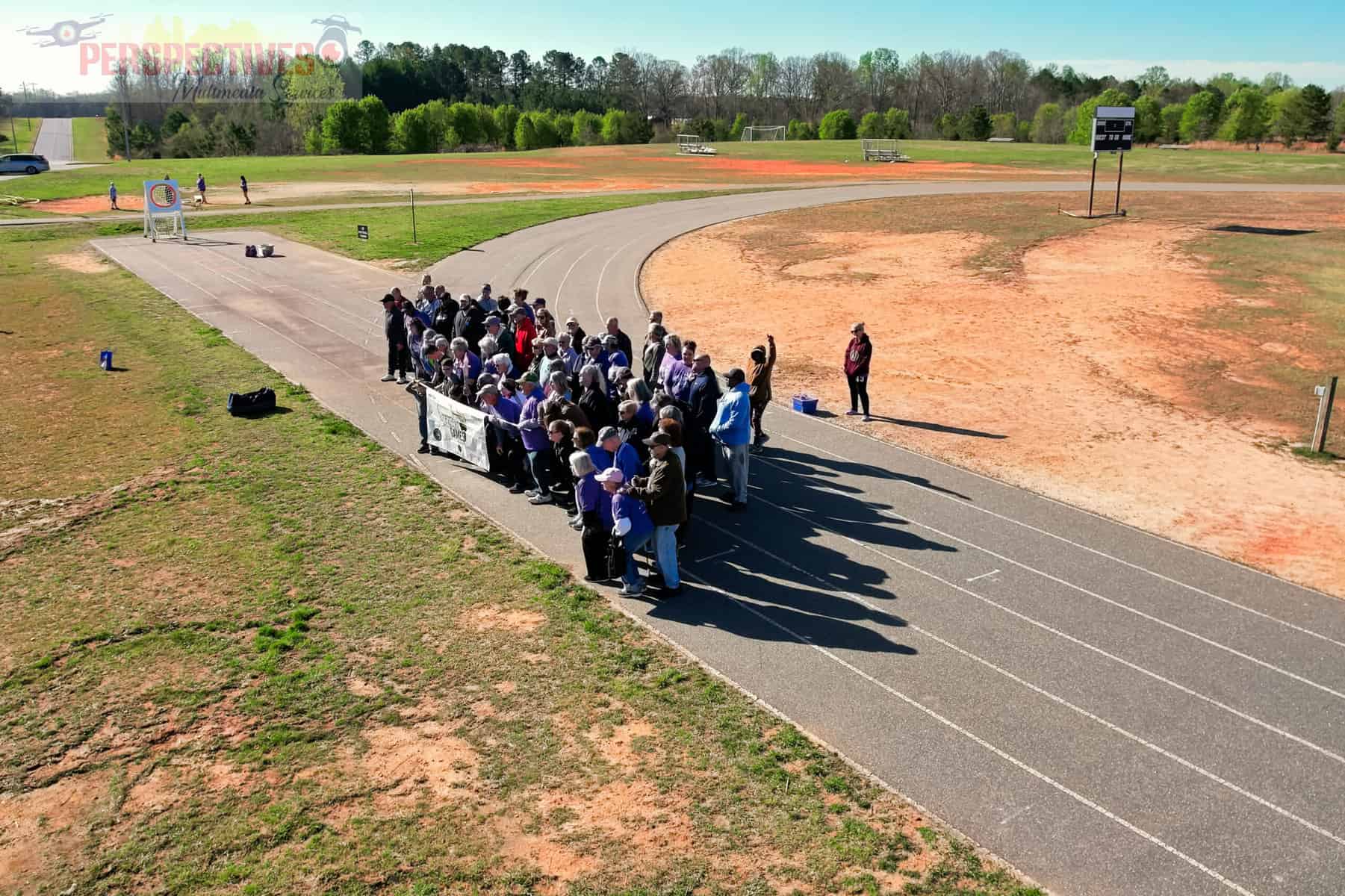 A group of people standing on a track.