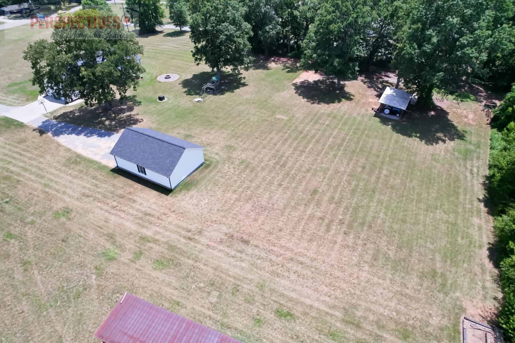 A house and trees in a field.