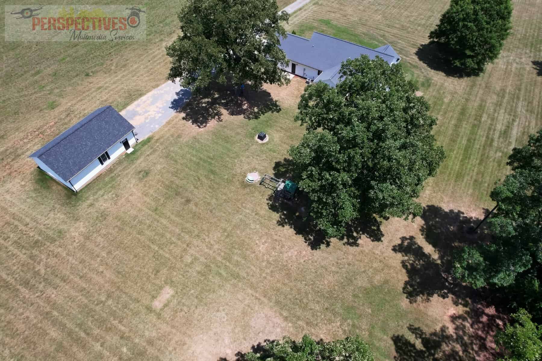 A house and trees in a field.