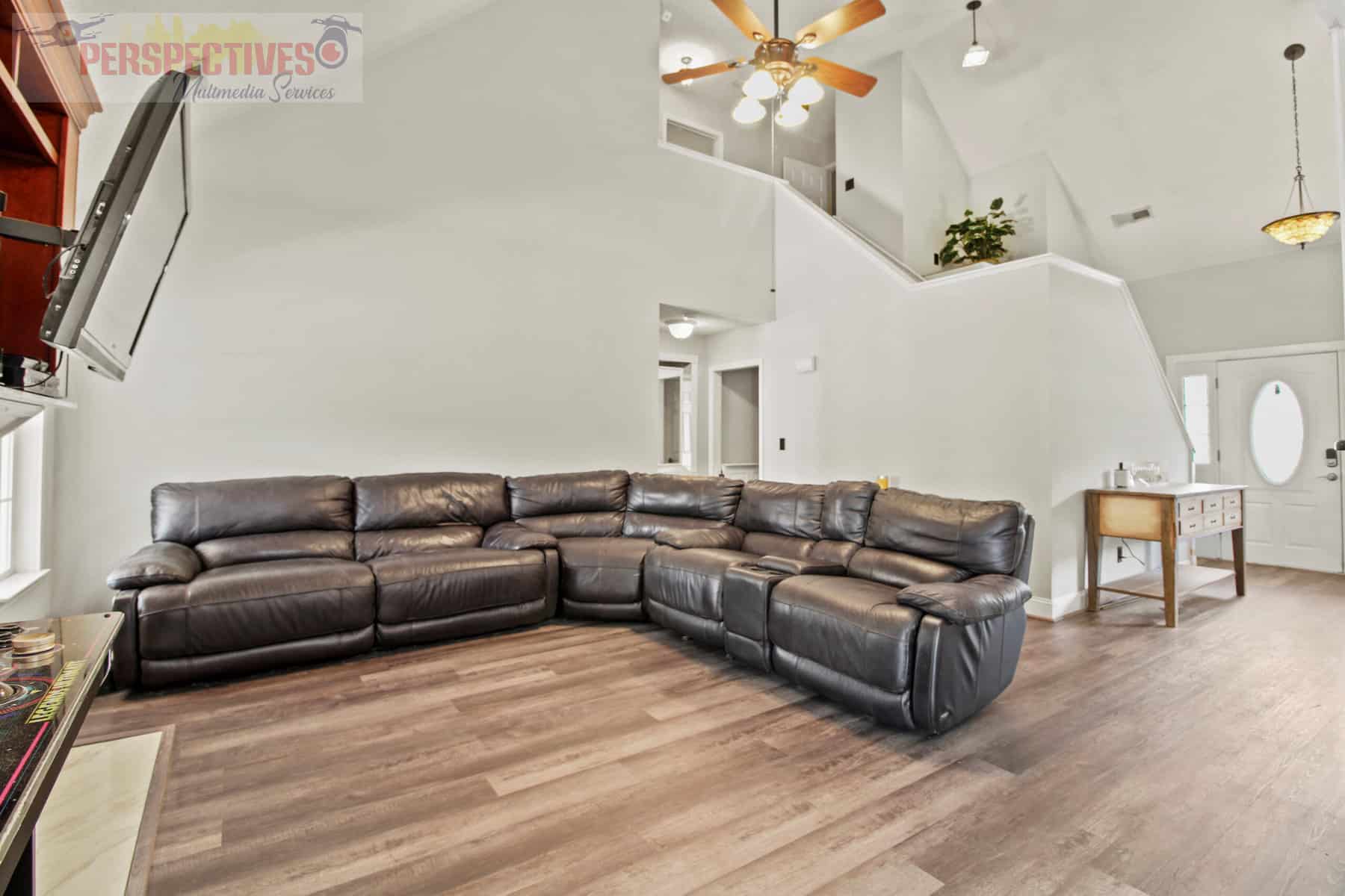 A living room with hardwood floors and a ceiling fan.