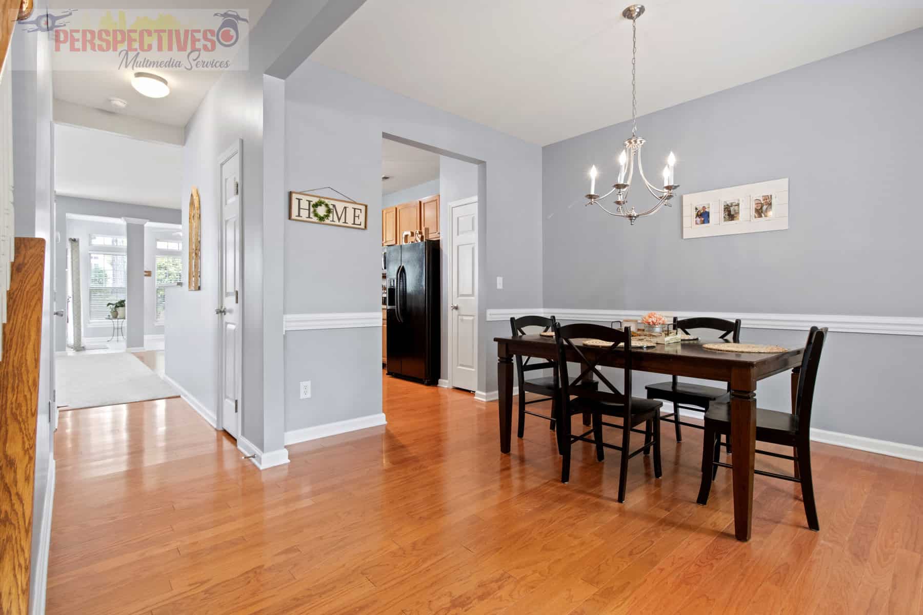 A dining room with hardwood floors and a table.