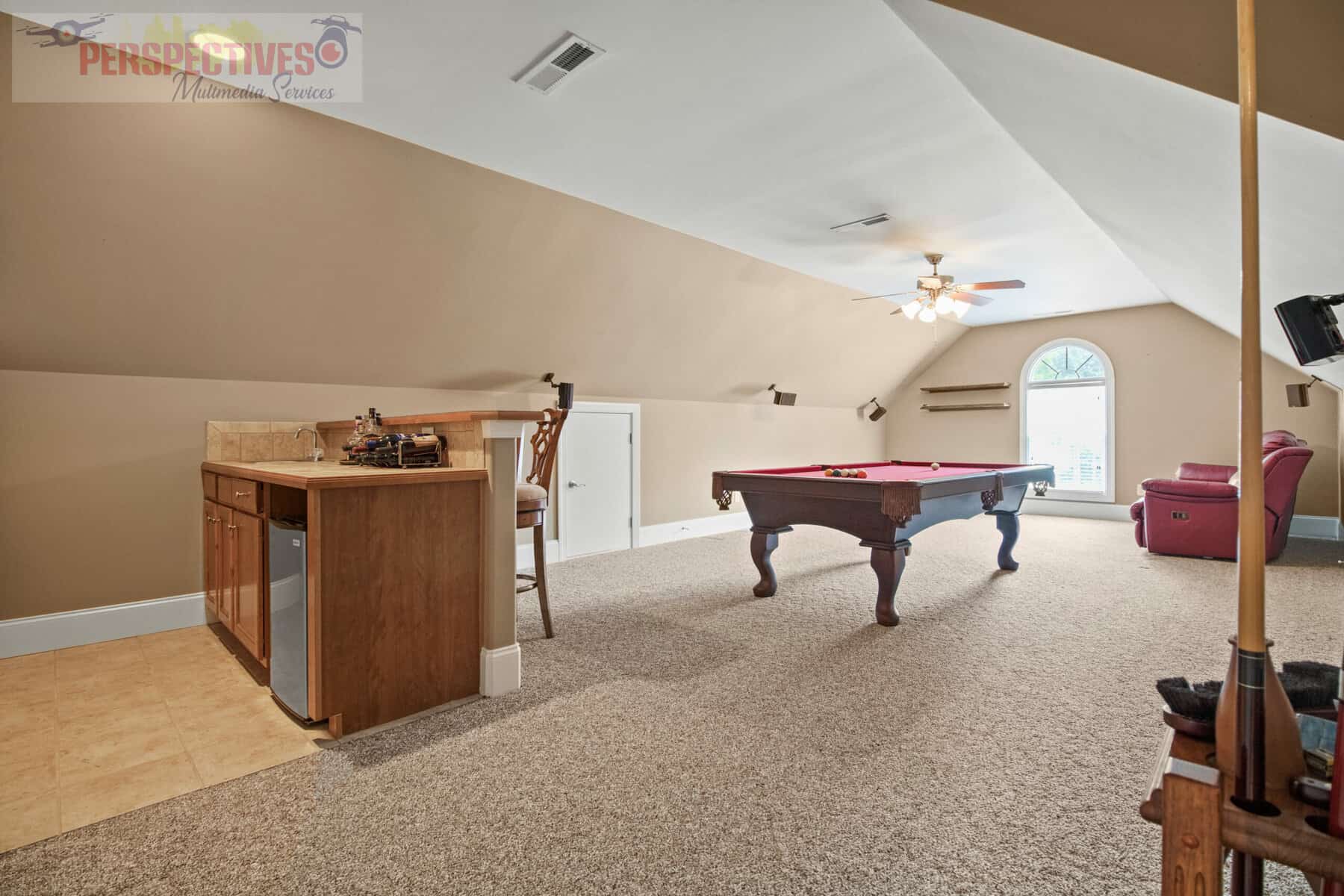 An attic room with a pool table and billiards.