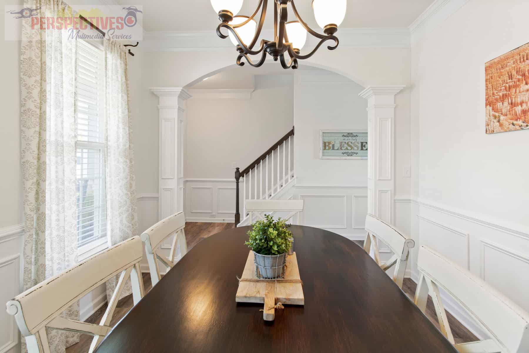 A dining room with a white table and chairs.