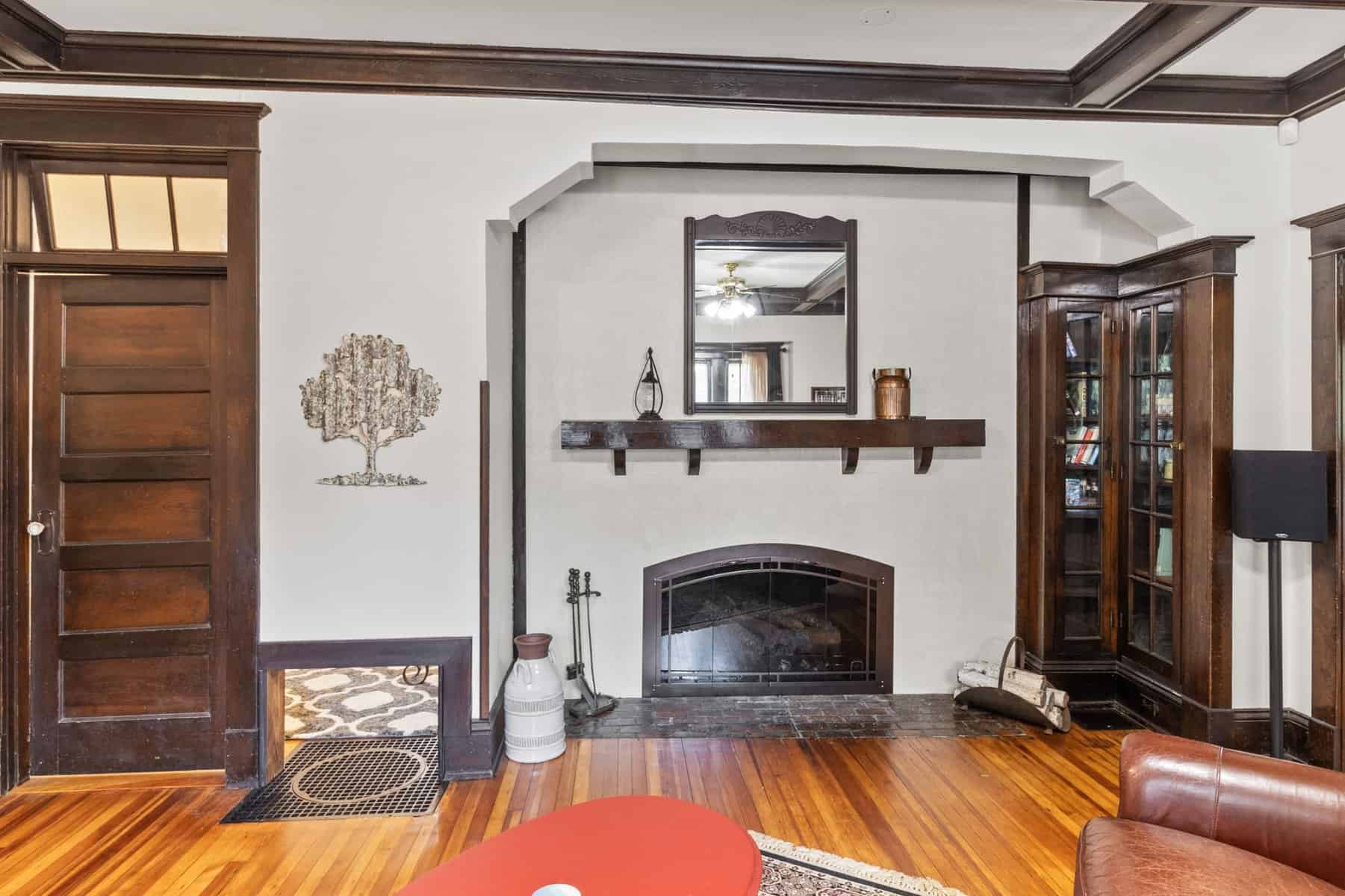 A living room with hardwood floors and a fireplace.