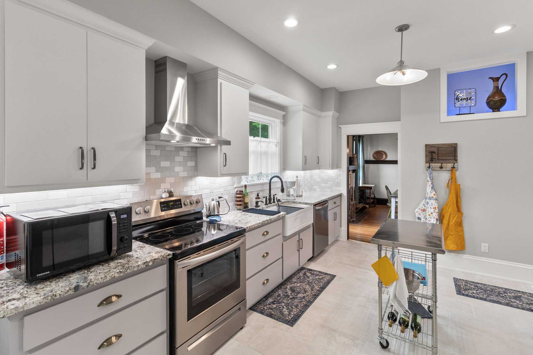 A kitchen with stainless steel appliances and white cabinets.