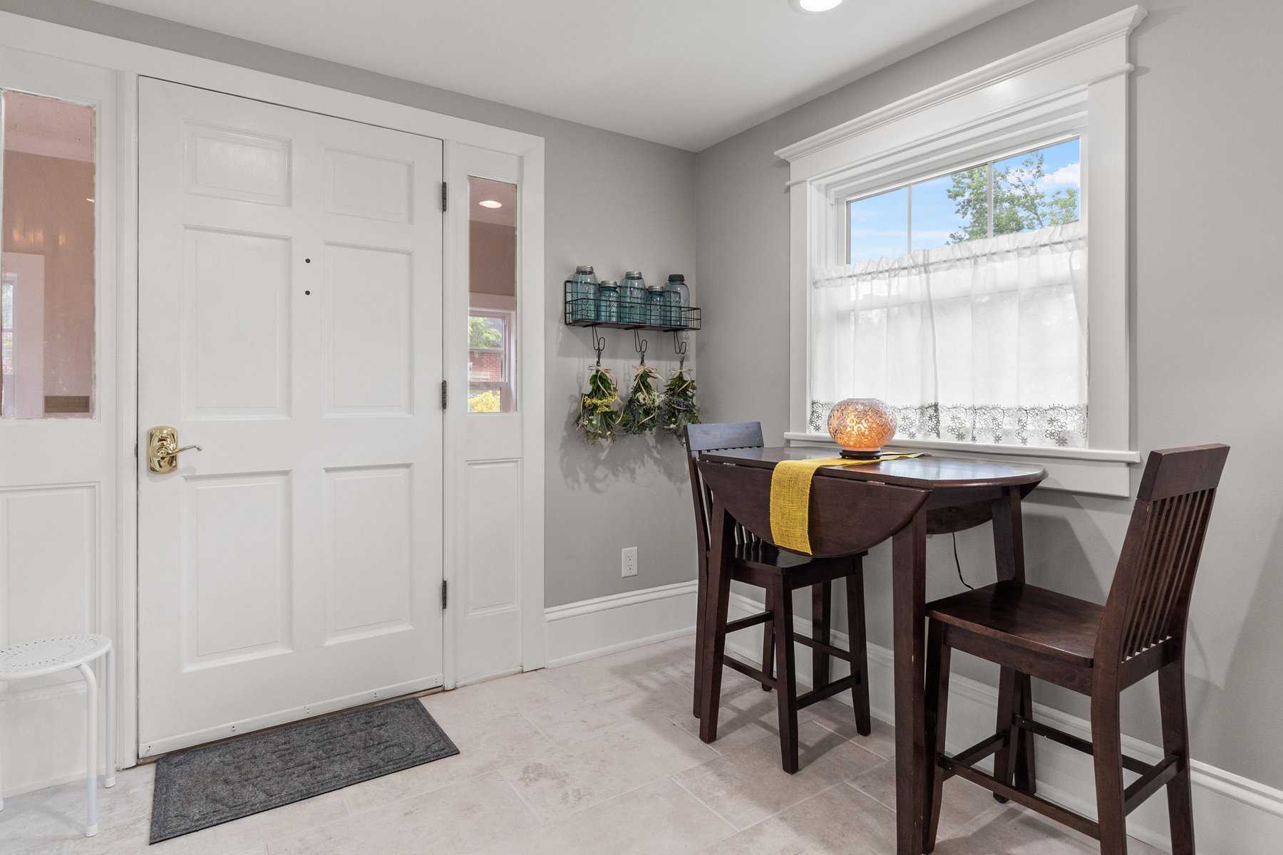 A room with a table and chairs and a door.