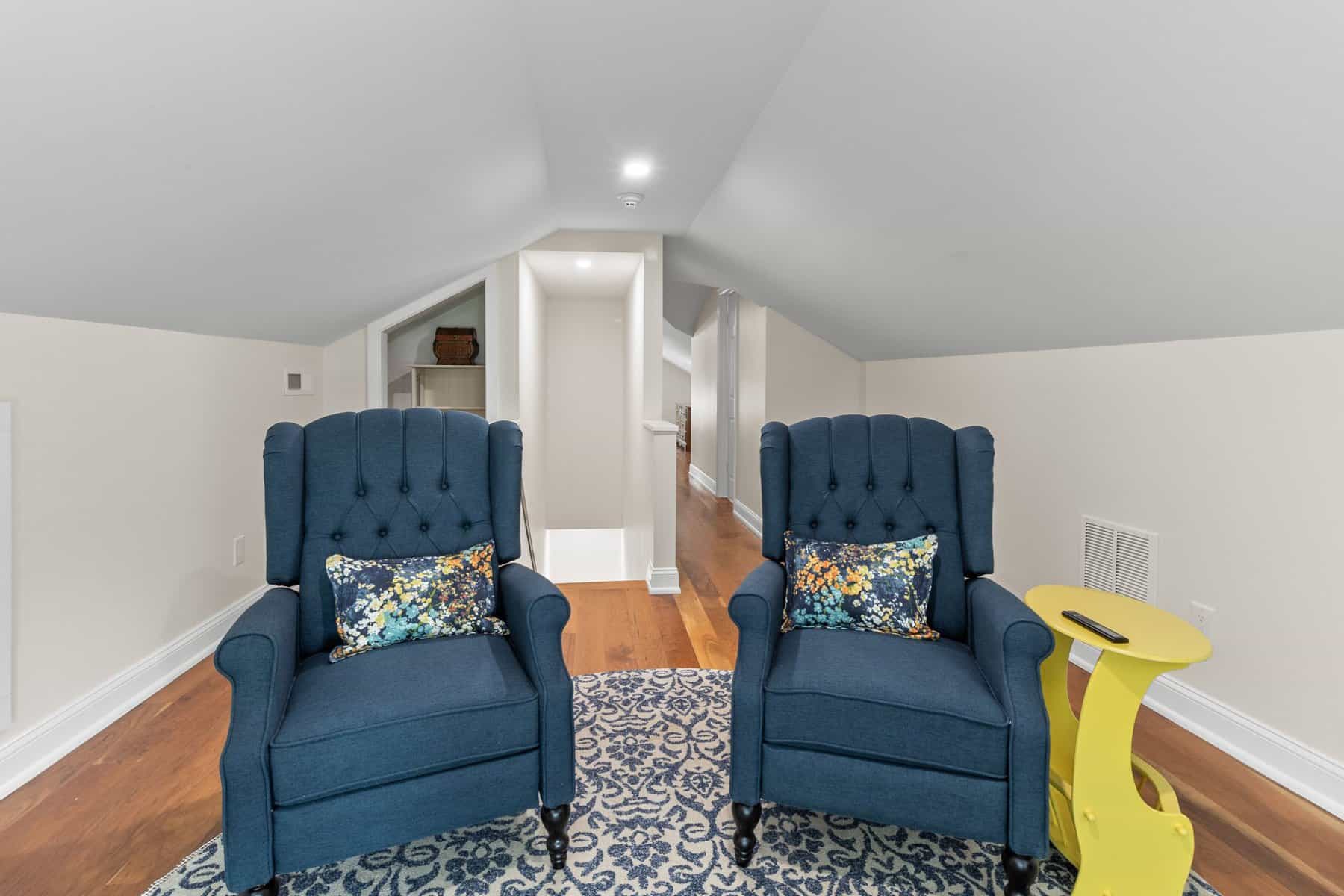 Two blue chairs are sitting in an attic.