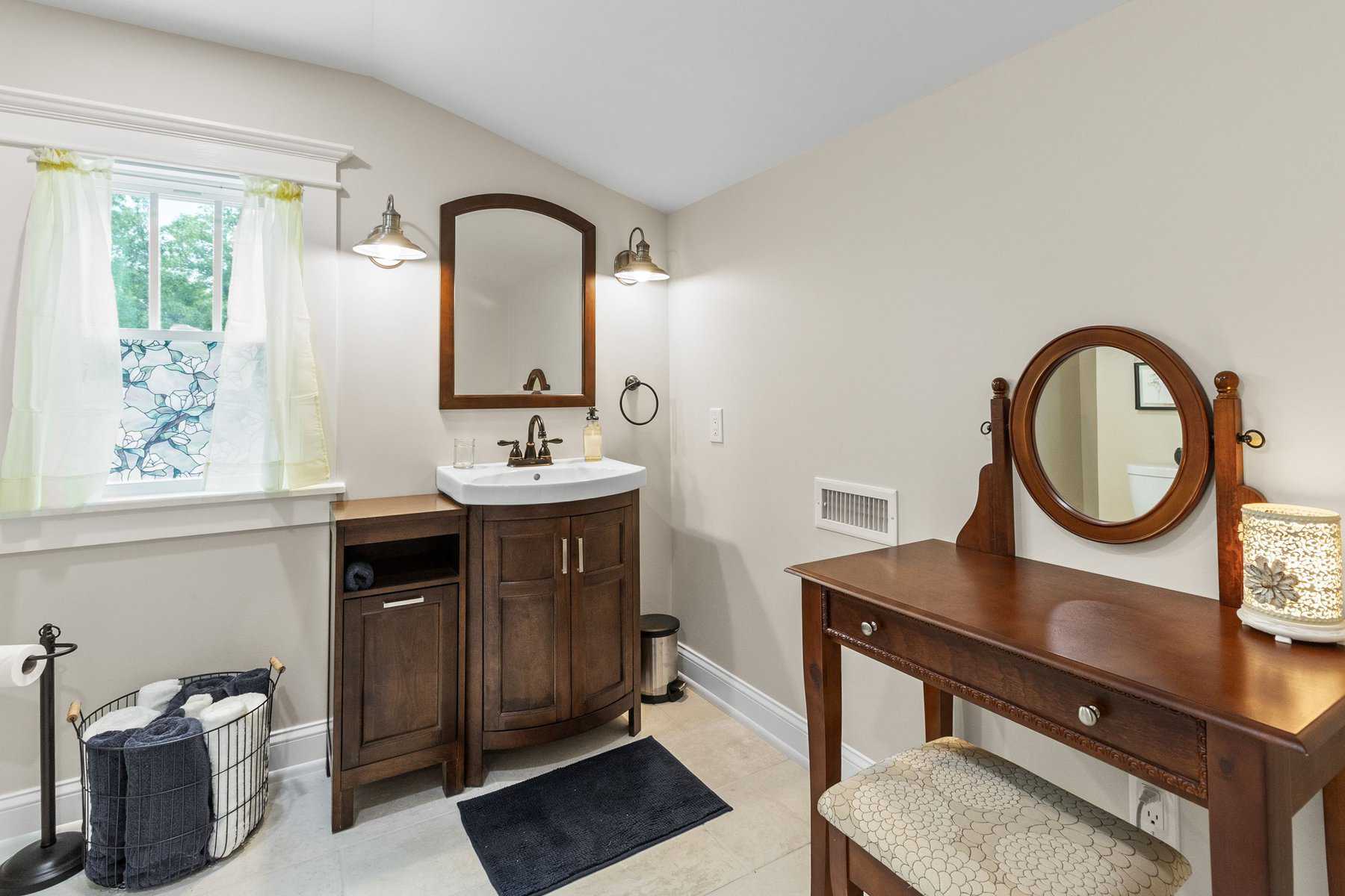 A bathroom with a vanity and mirror.