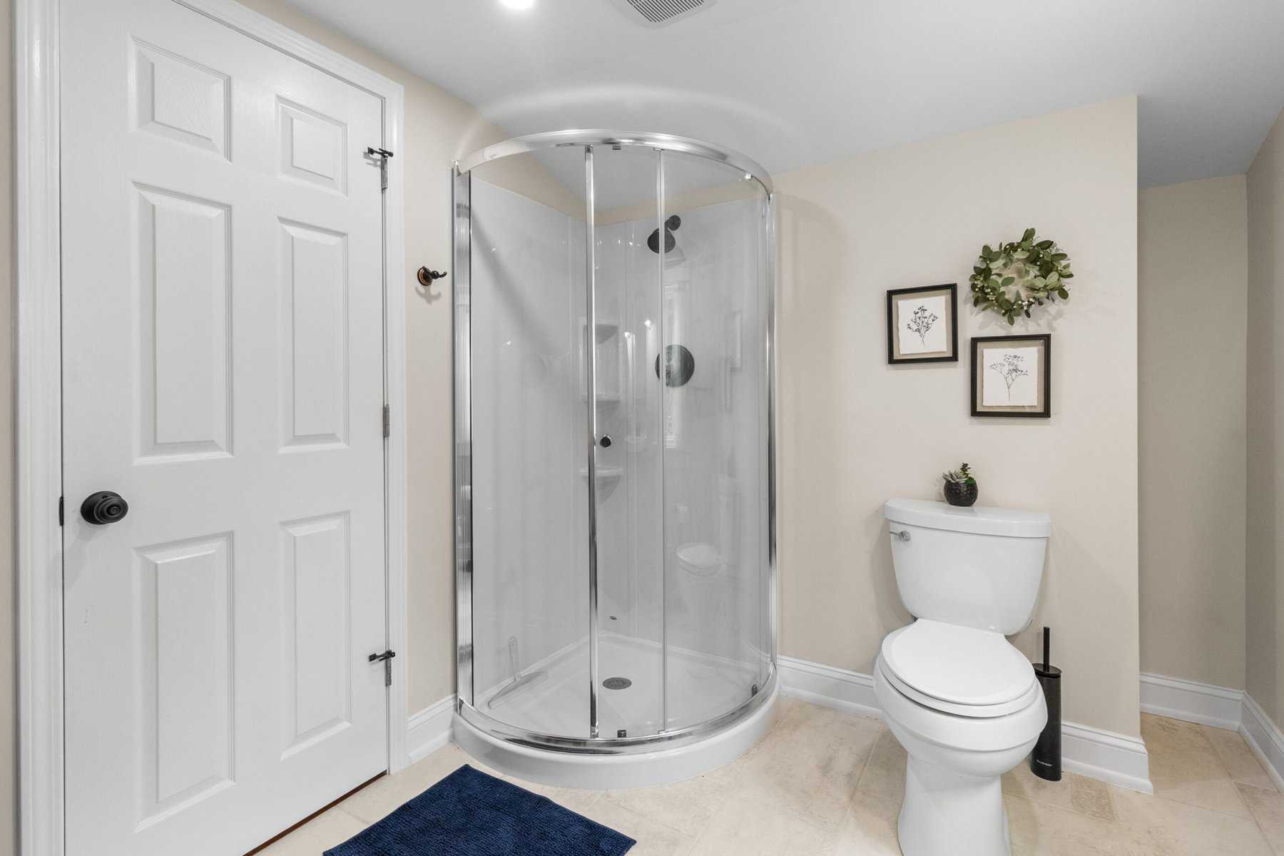 A white bathroom with a shower stall and toilet.