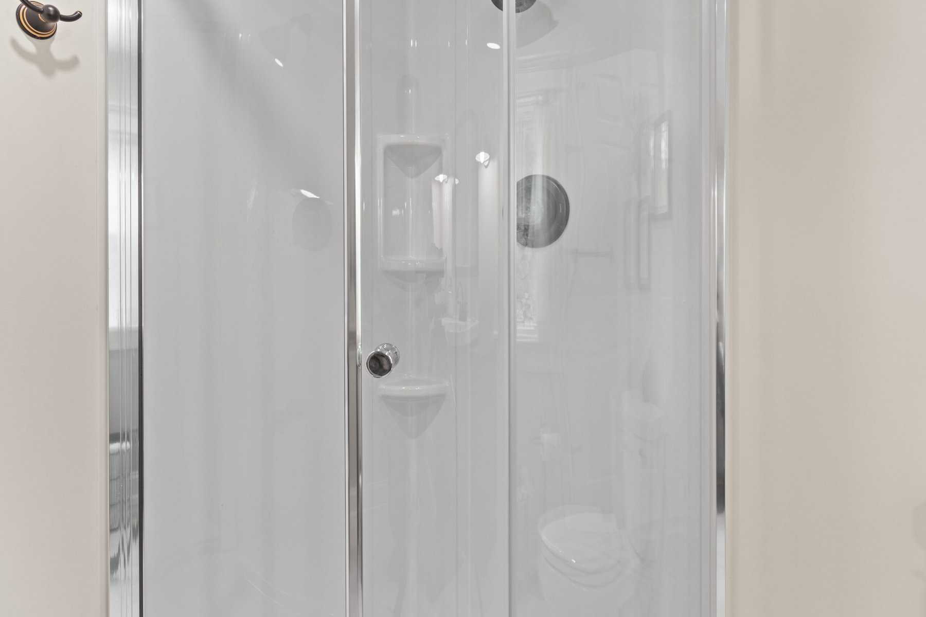 A white shower stall with a glass door.