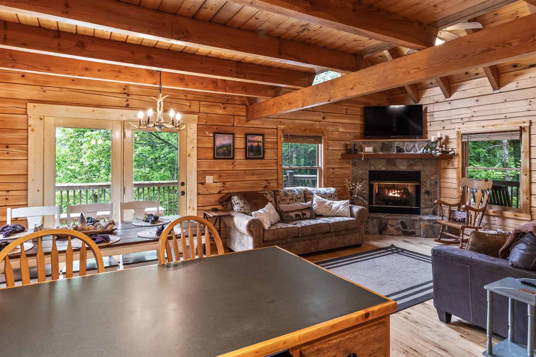 The living room of a log cabin with a fireplace.