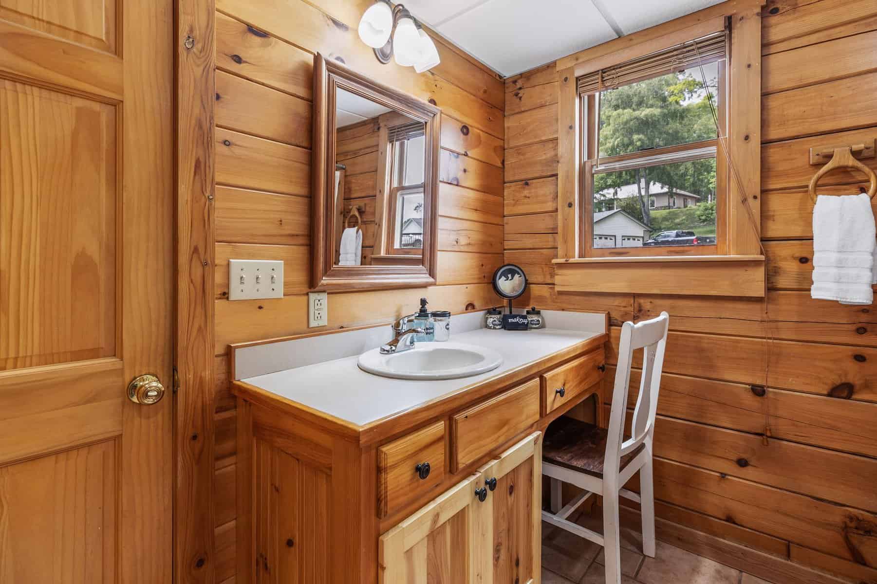 A bathroom with wood paneling and a sink.