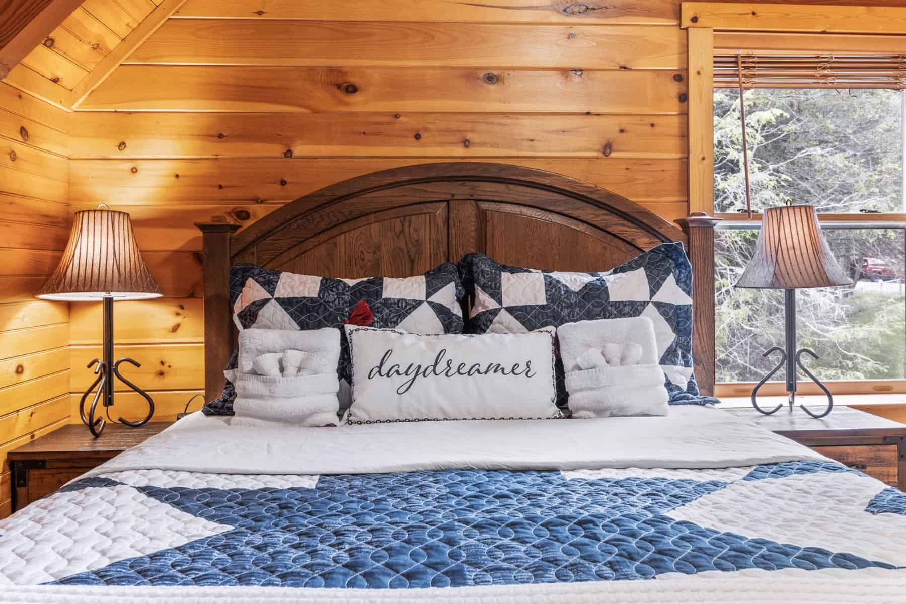 A bedroom in a log cabin with a blue and white star on the bed.