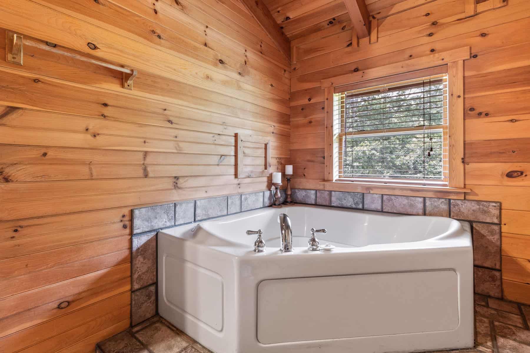 A bathroom with a jacuzzi tub in a log cabin.