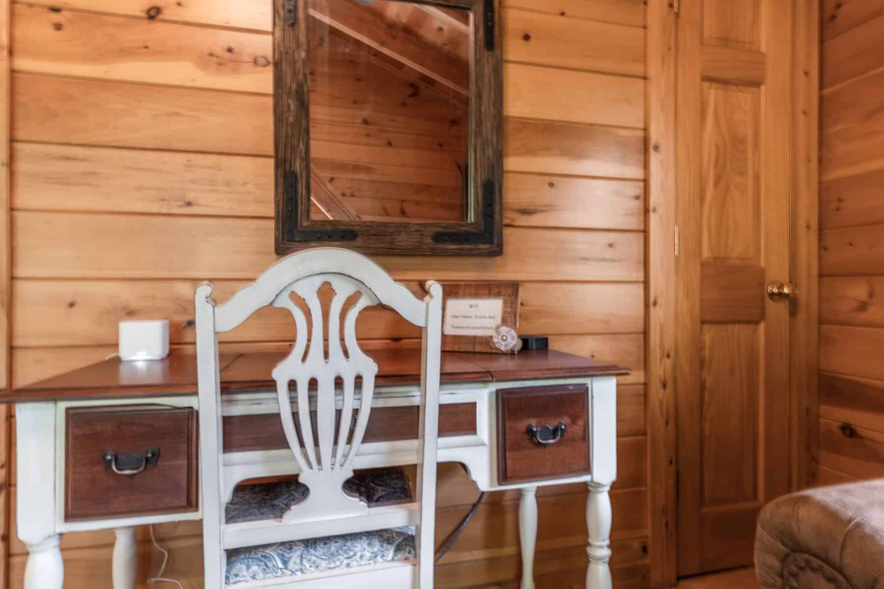 A wooden desk and chair in a cabin.