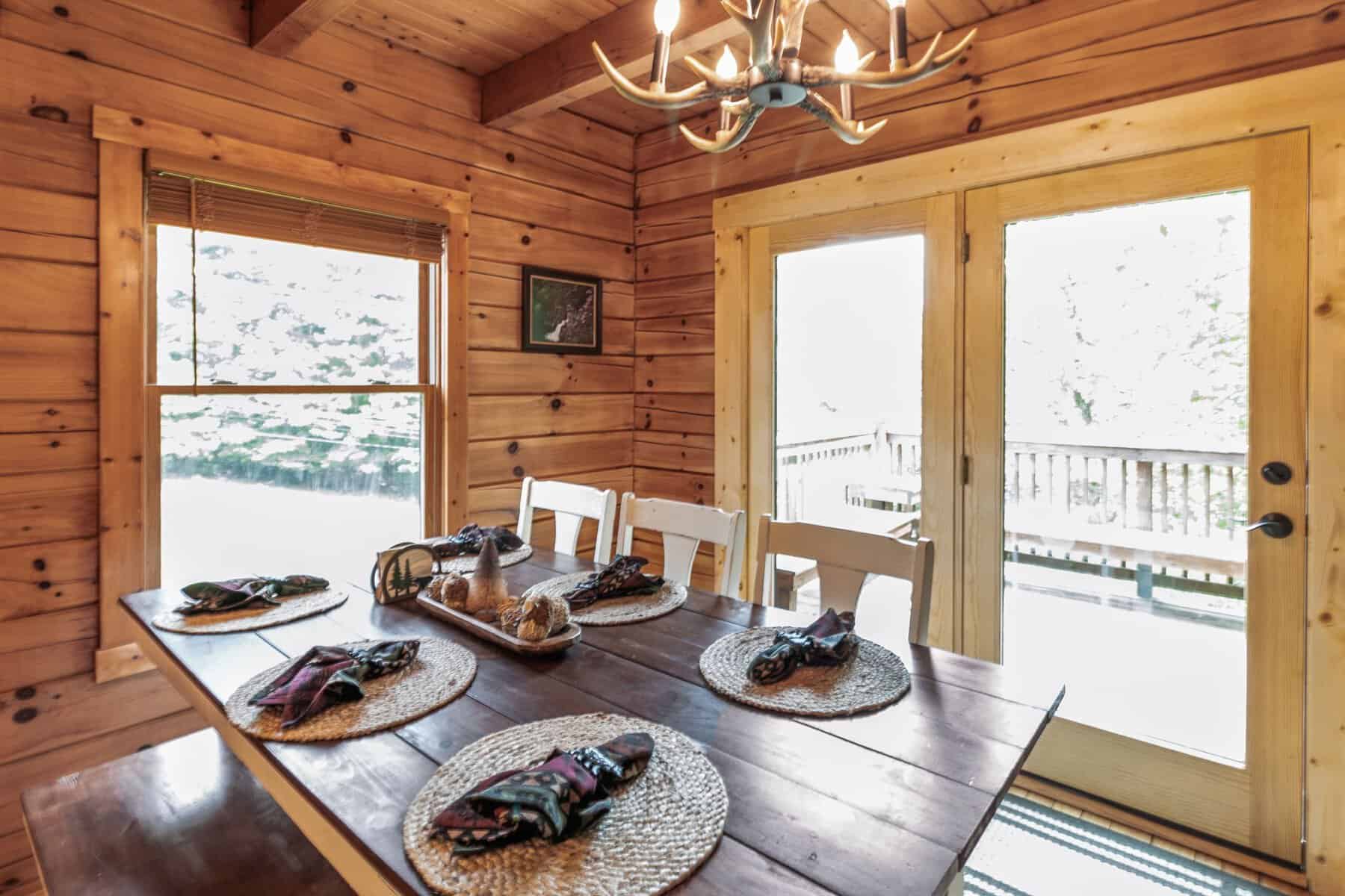 A dining table and chairs in a log cabin.