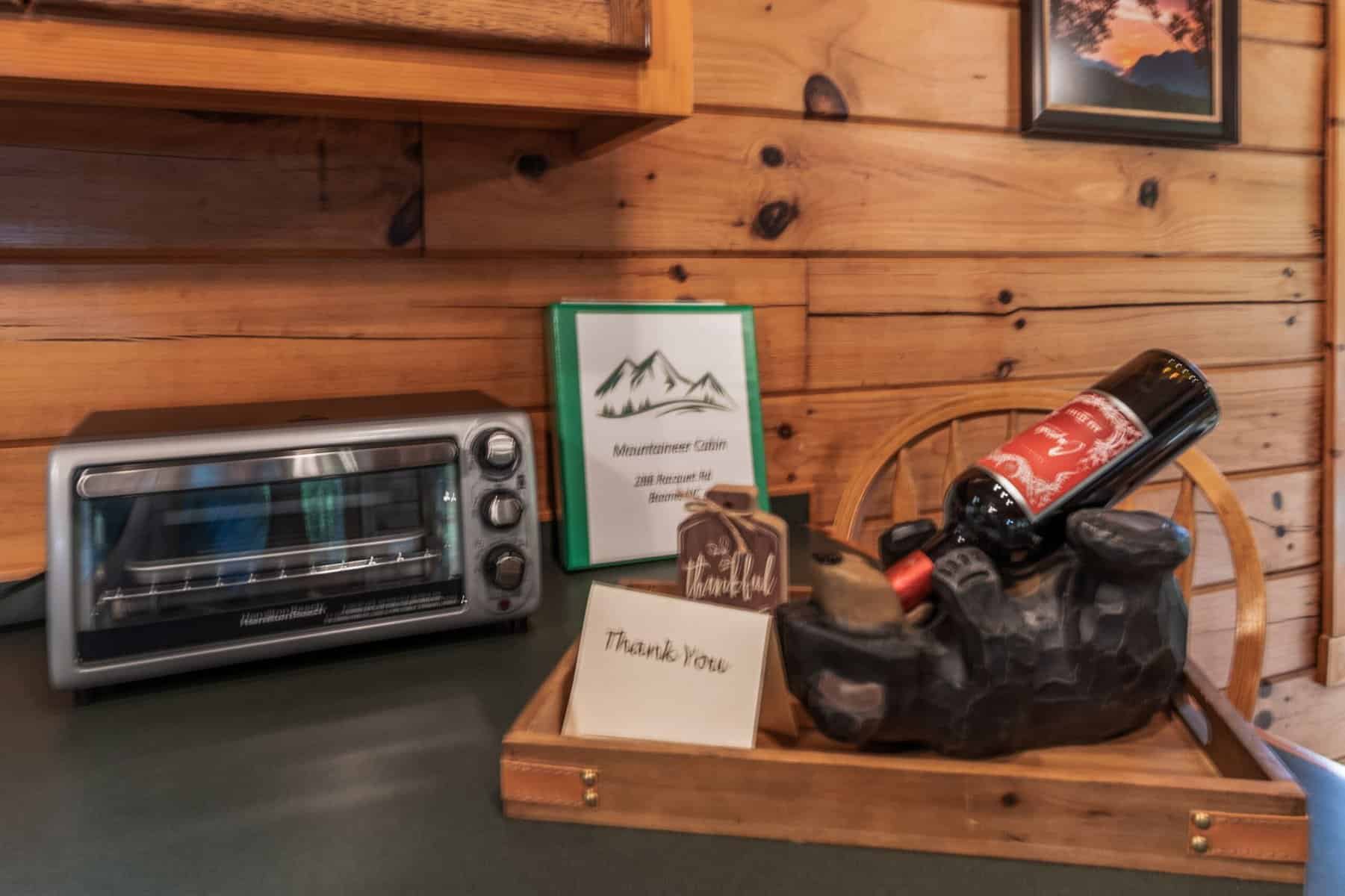 A tray with a bottle of wine and a toaster.