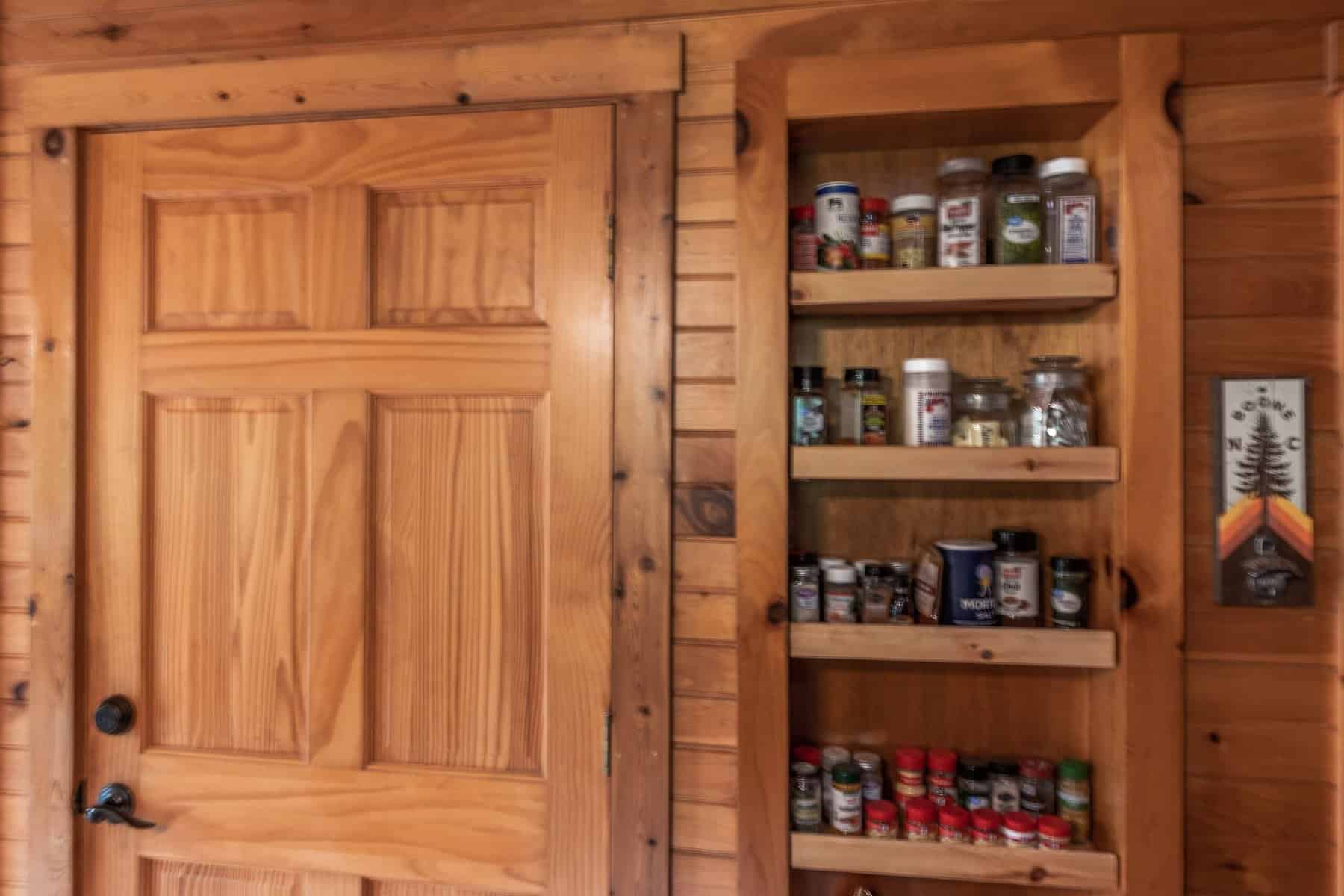 A wooden door with a spice rack in it.