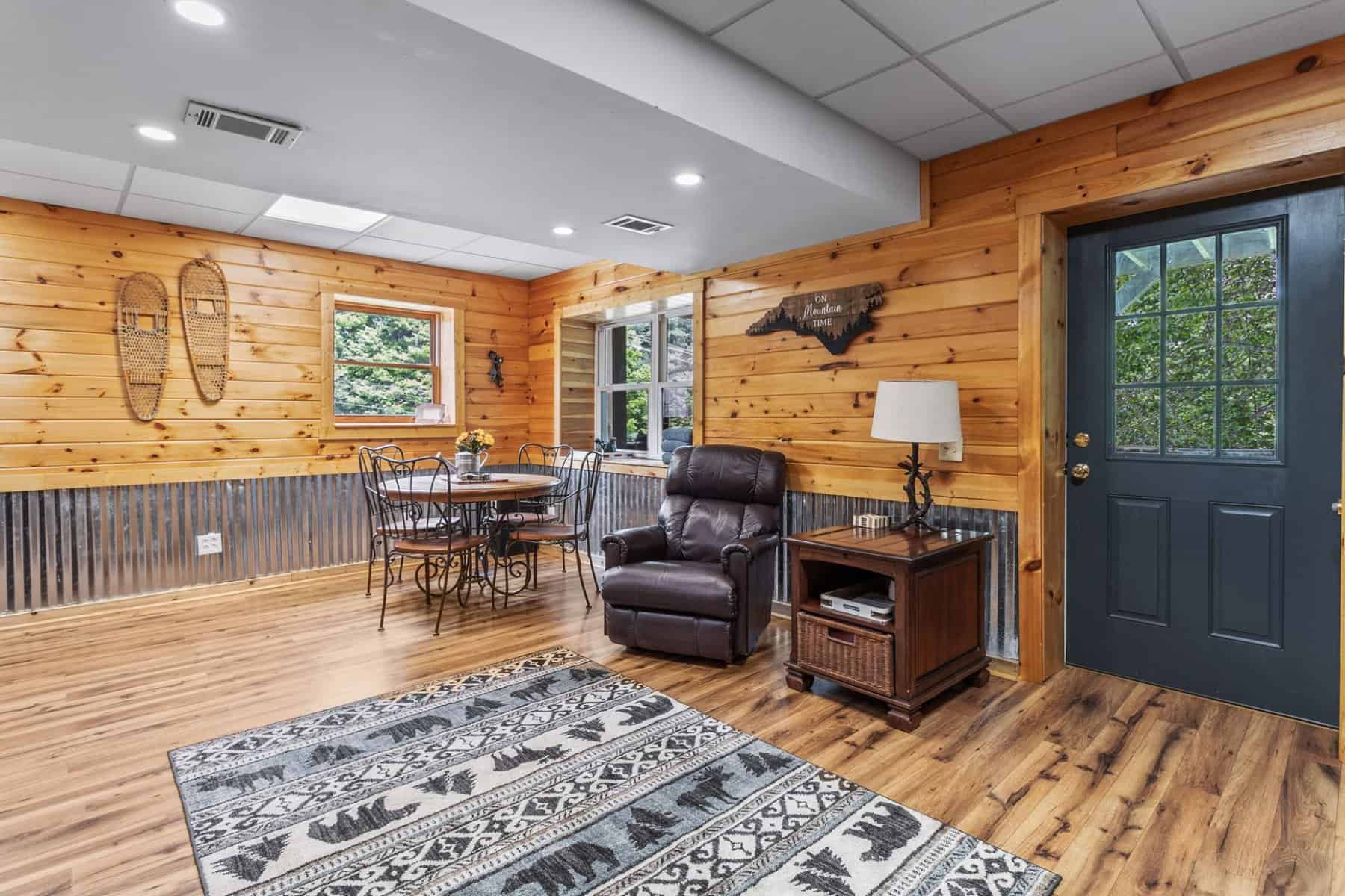 A living room with wood paneling and a fireplace.