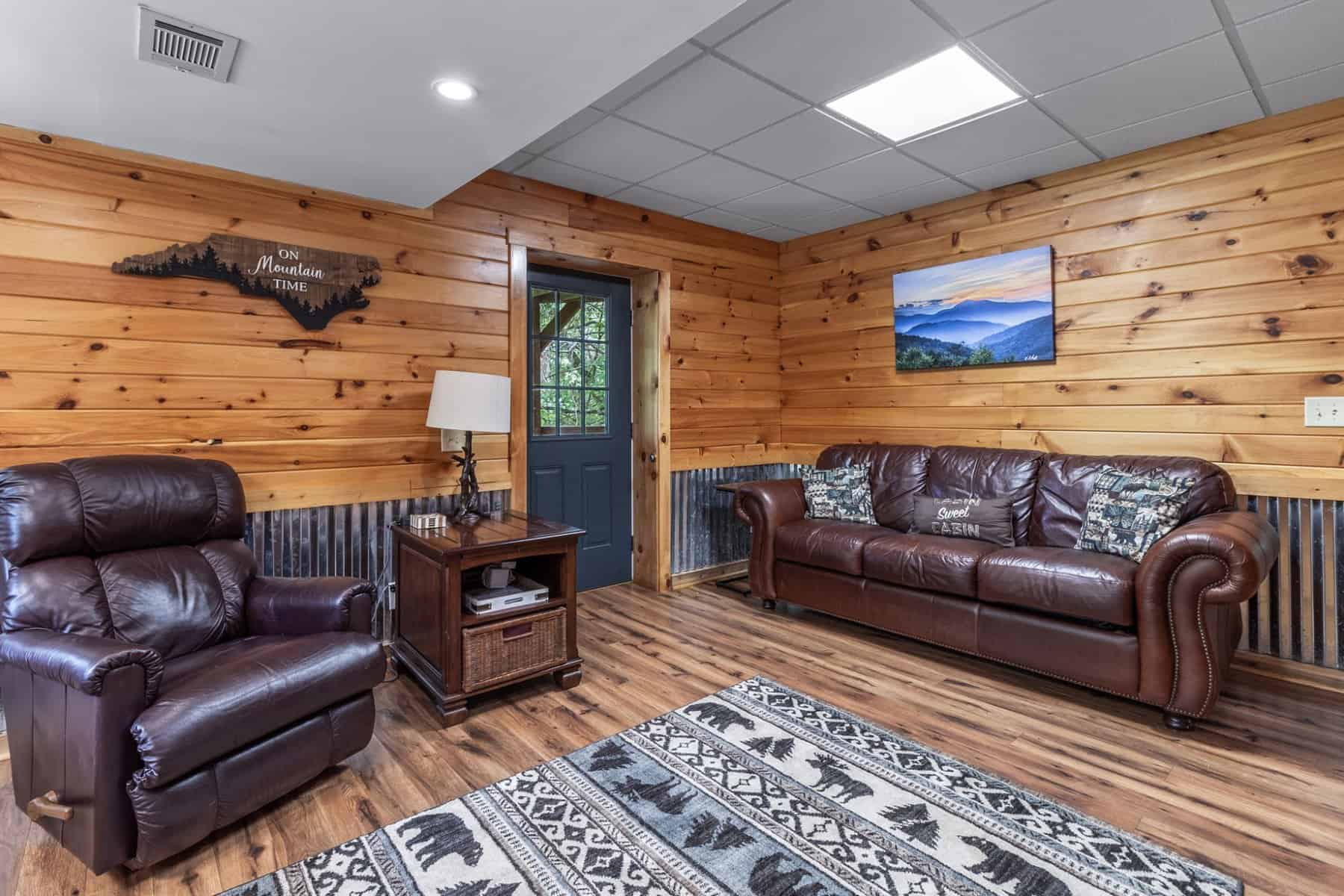 A living room with leather furniture and wood paneling.