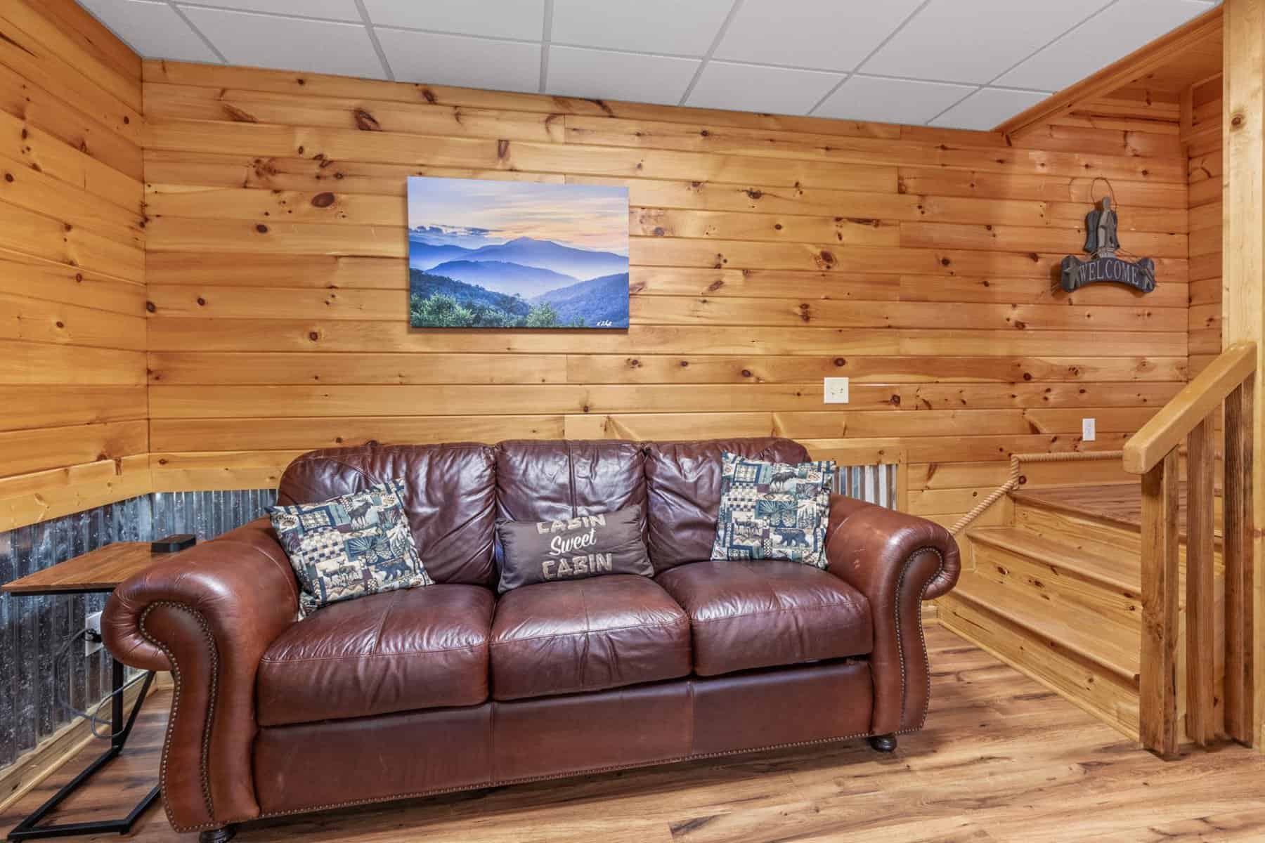 A living room with a leather couch and a fireplace.