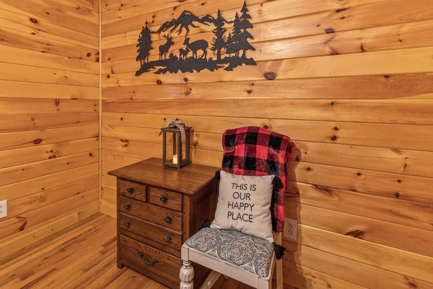 A room in a cabin with wood walls and a chair.