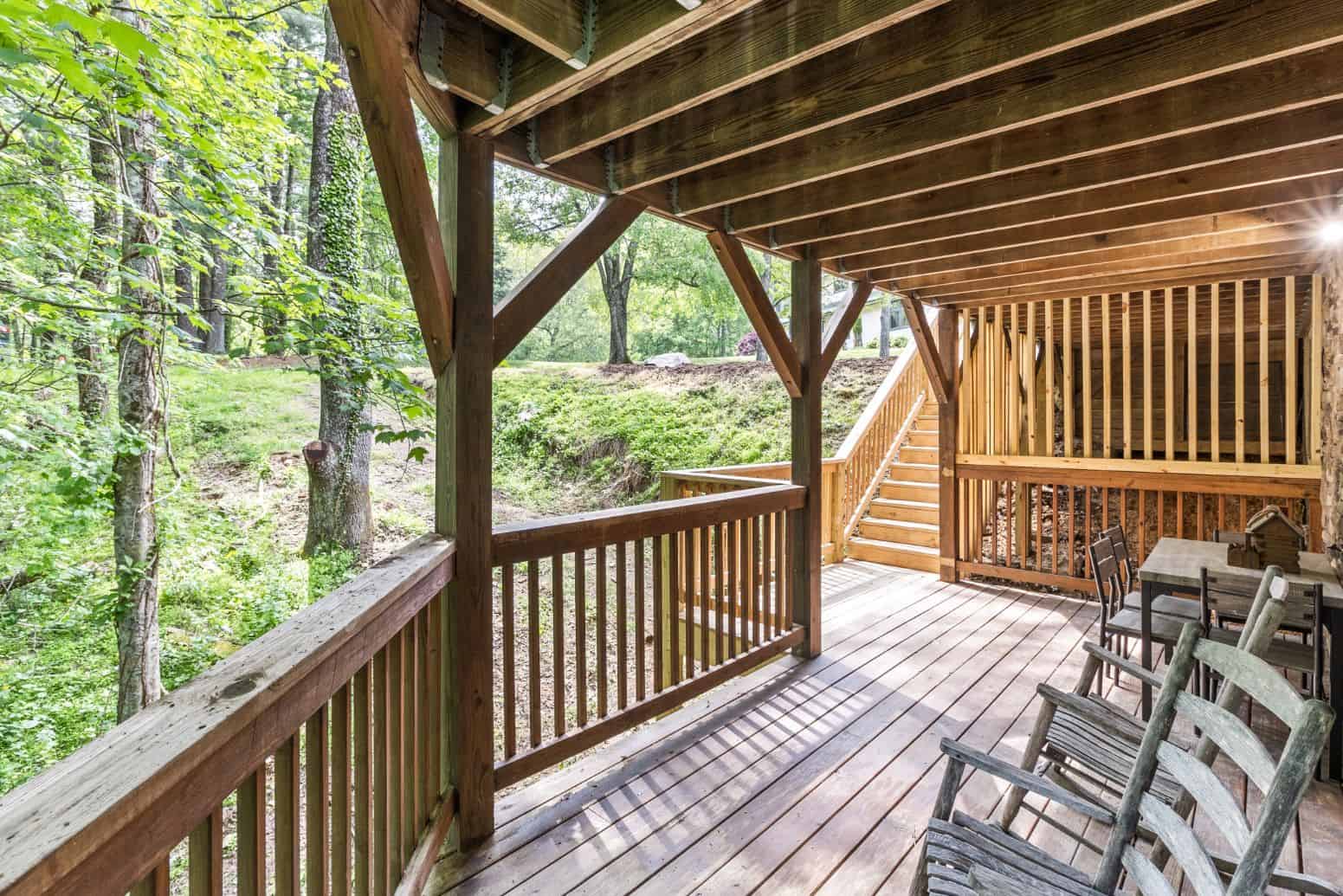 A deck with a view of a wooded area.