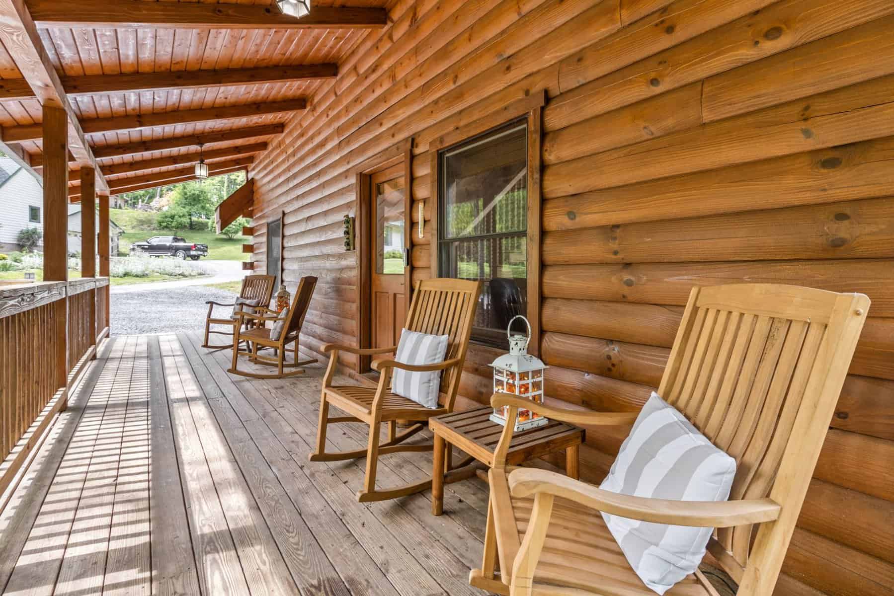 Rocking chairs on the porch of a log cabin.