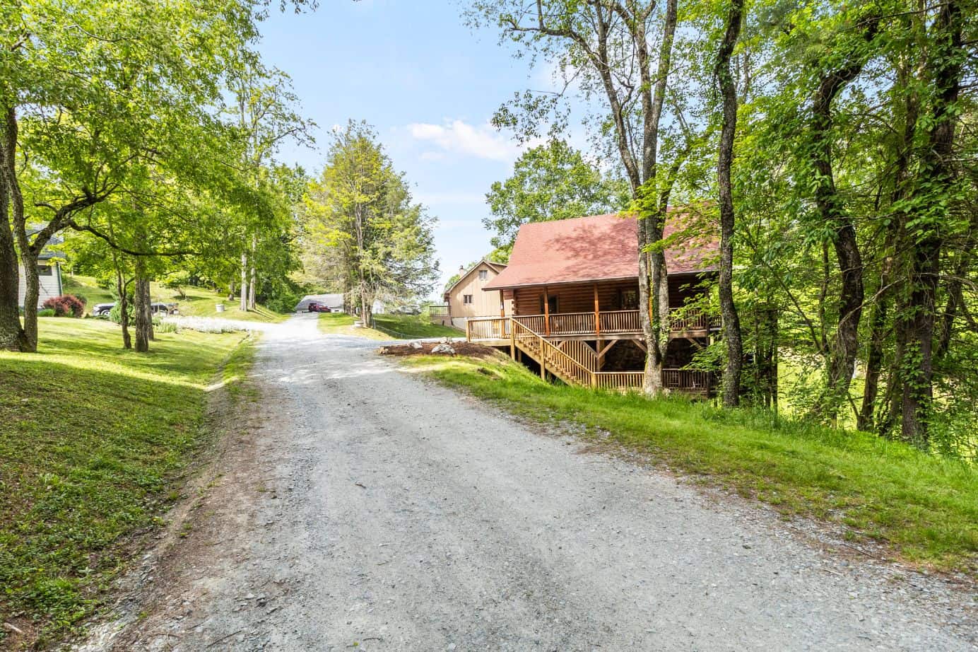 A dirt road leading to a cabin in the woods.