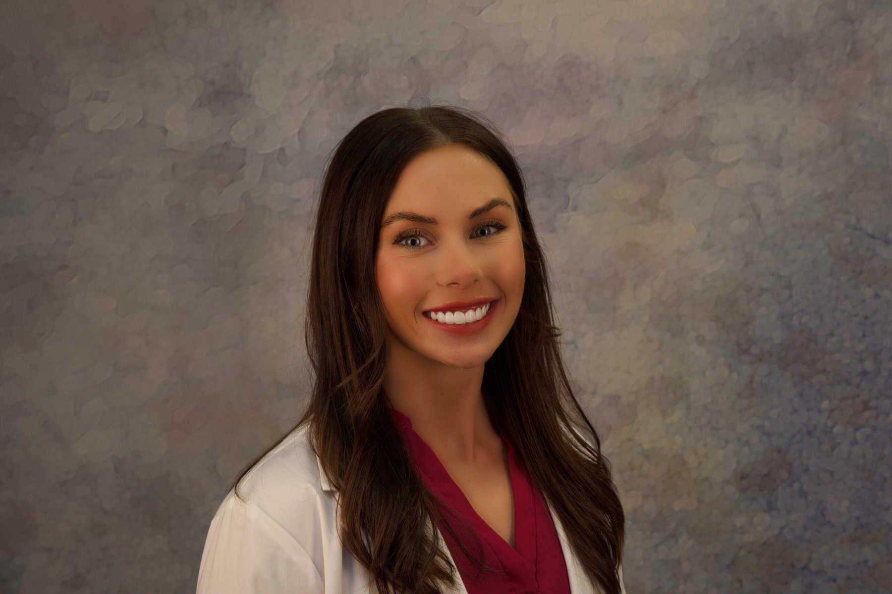 A female doctor in a lab coat posing for a photo.