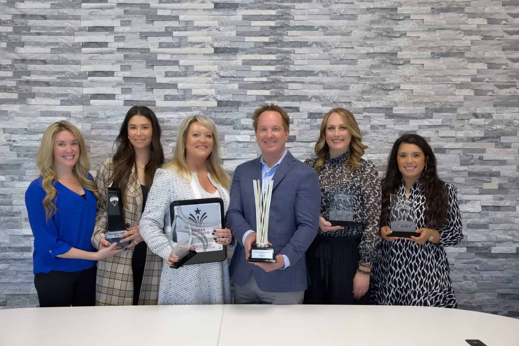 A group of people posing for a picture with their awards.