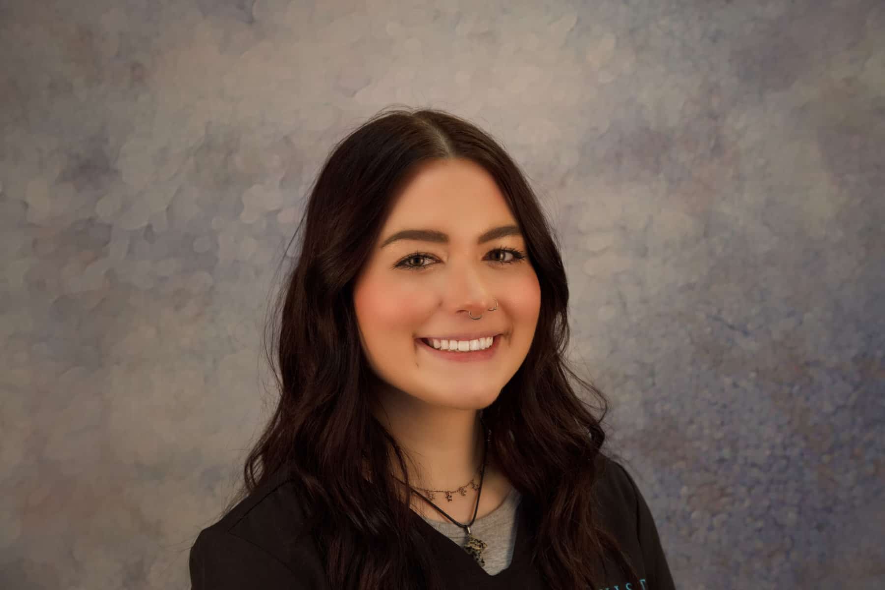 A smiling woman wearing a black shirt.