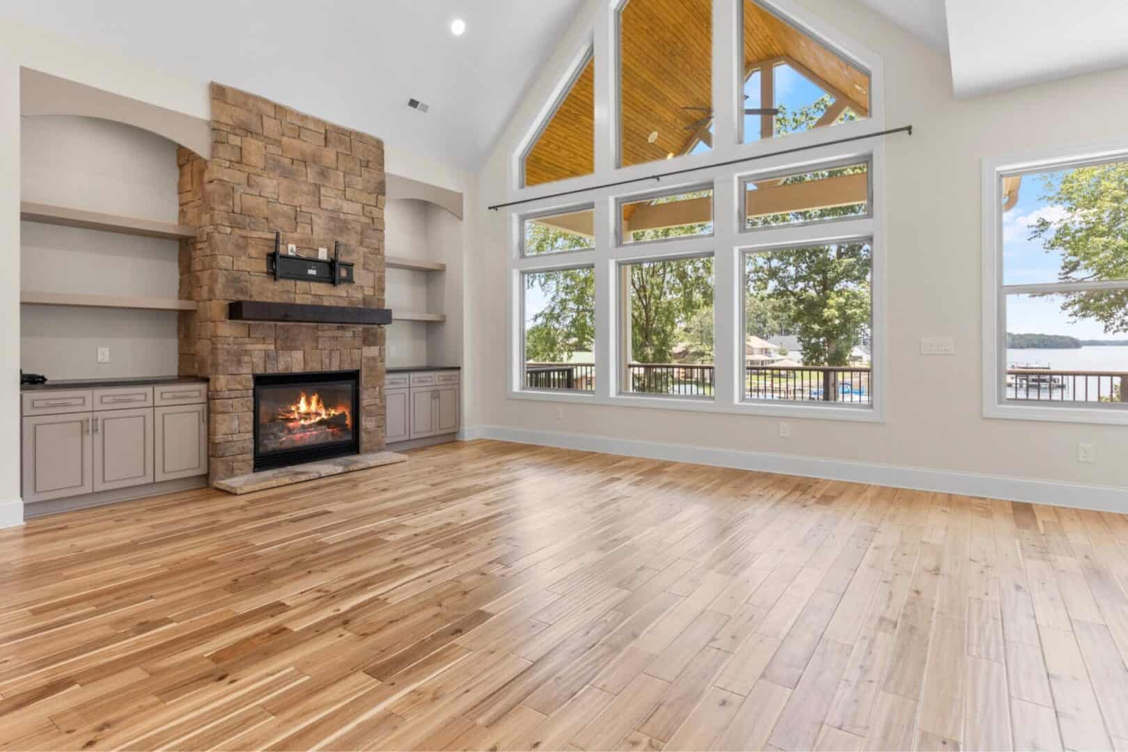 An empty living room with hardwood floors and a fireplace.