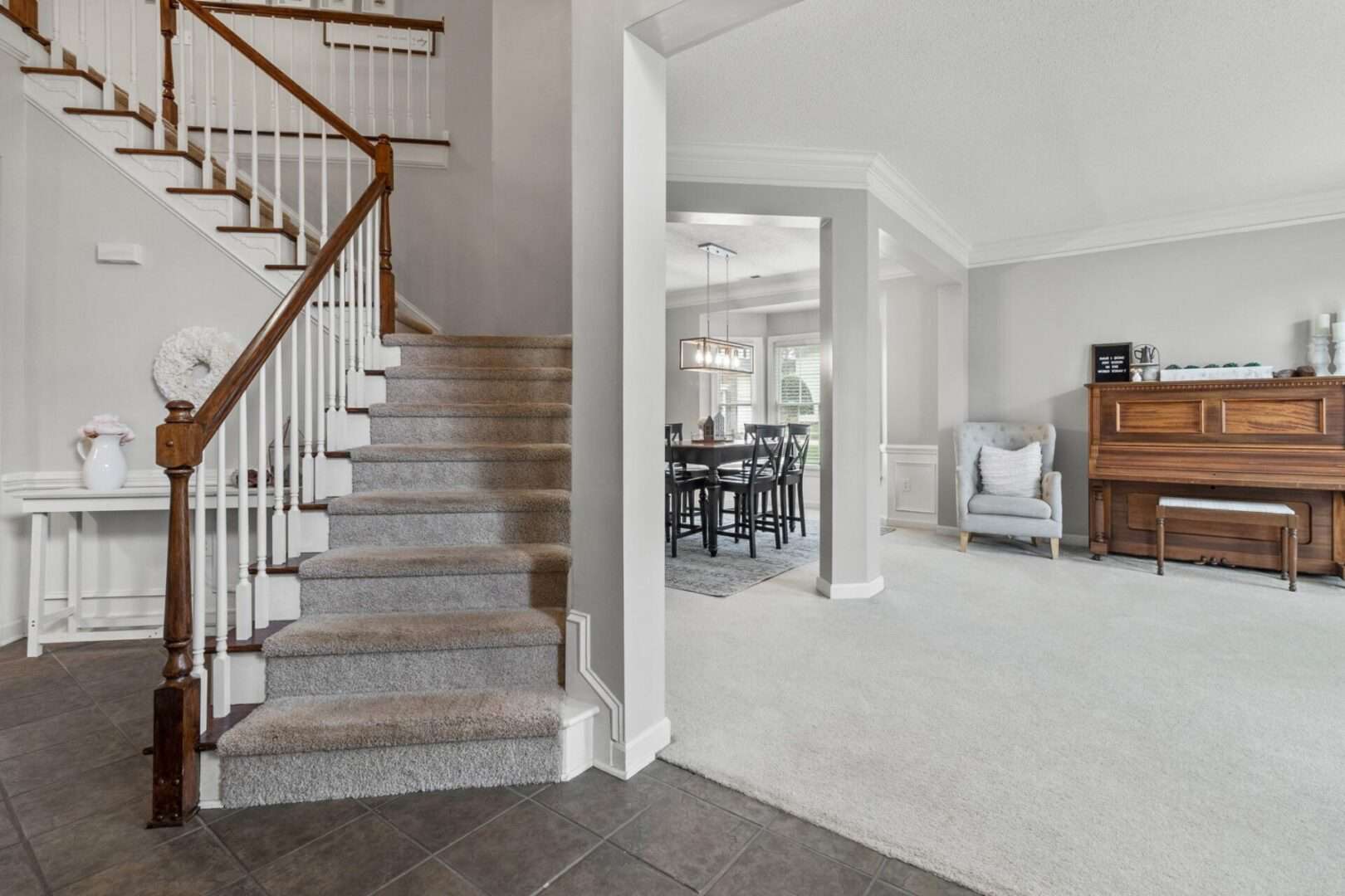 A living room with stairs and a piano.