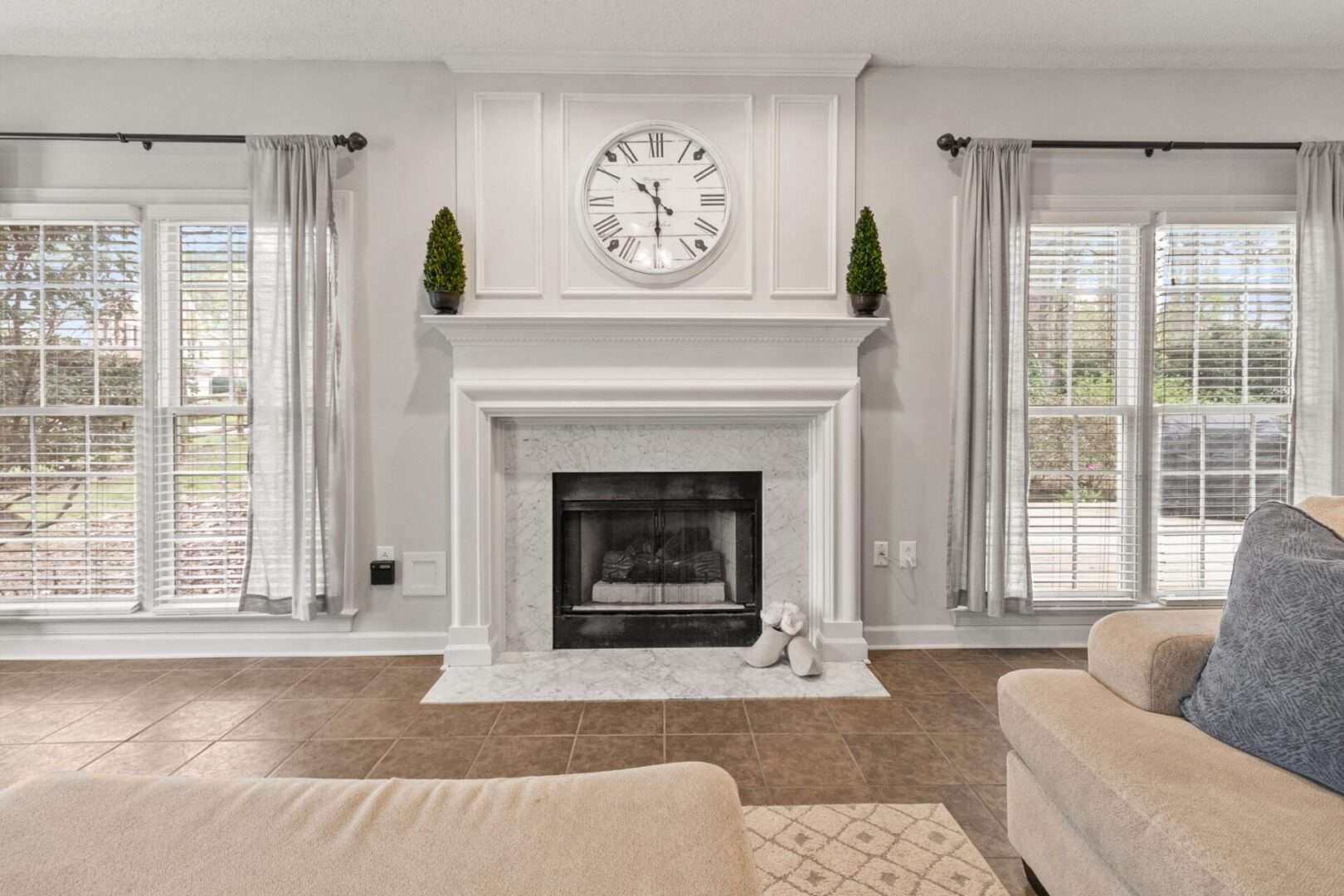 A living room with a fireplace and a clock.